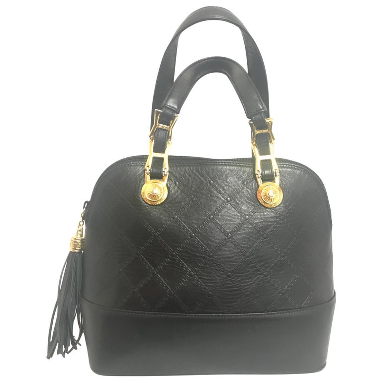 Gianni Versace Vintage black bolide shape bag with a tassel and sunburst motifs  For Sale