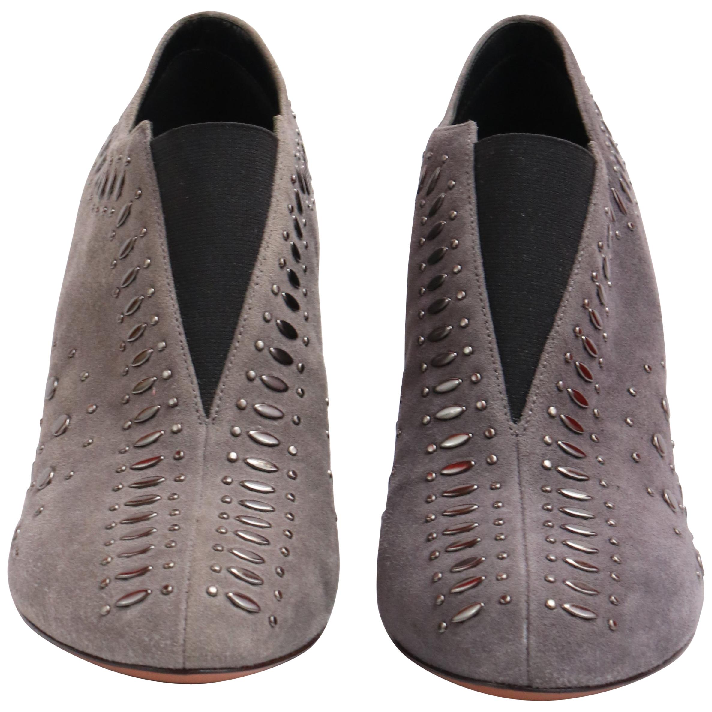 These pair of ALAIA heels are the perfect winter shoes! Made with grey suede and an intricate studded design. 
Would look great with any casual daytime look or classy night look. 
NBW
Comes with original shoebox that has an amazing leather strap and