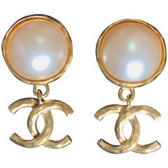 Vintage CHANEL classic round white faux pearl and golden CC dangling earrings.