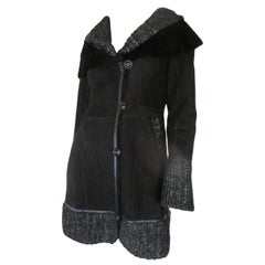 Cappotto in pelliccia di shearling nero con dettagli in maglia argentata