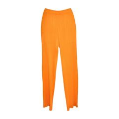 Die charakteristischen plissierten Hosen aus braunem Tangerine von Issey Miyake