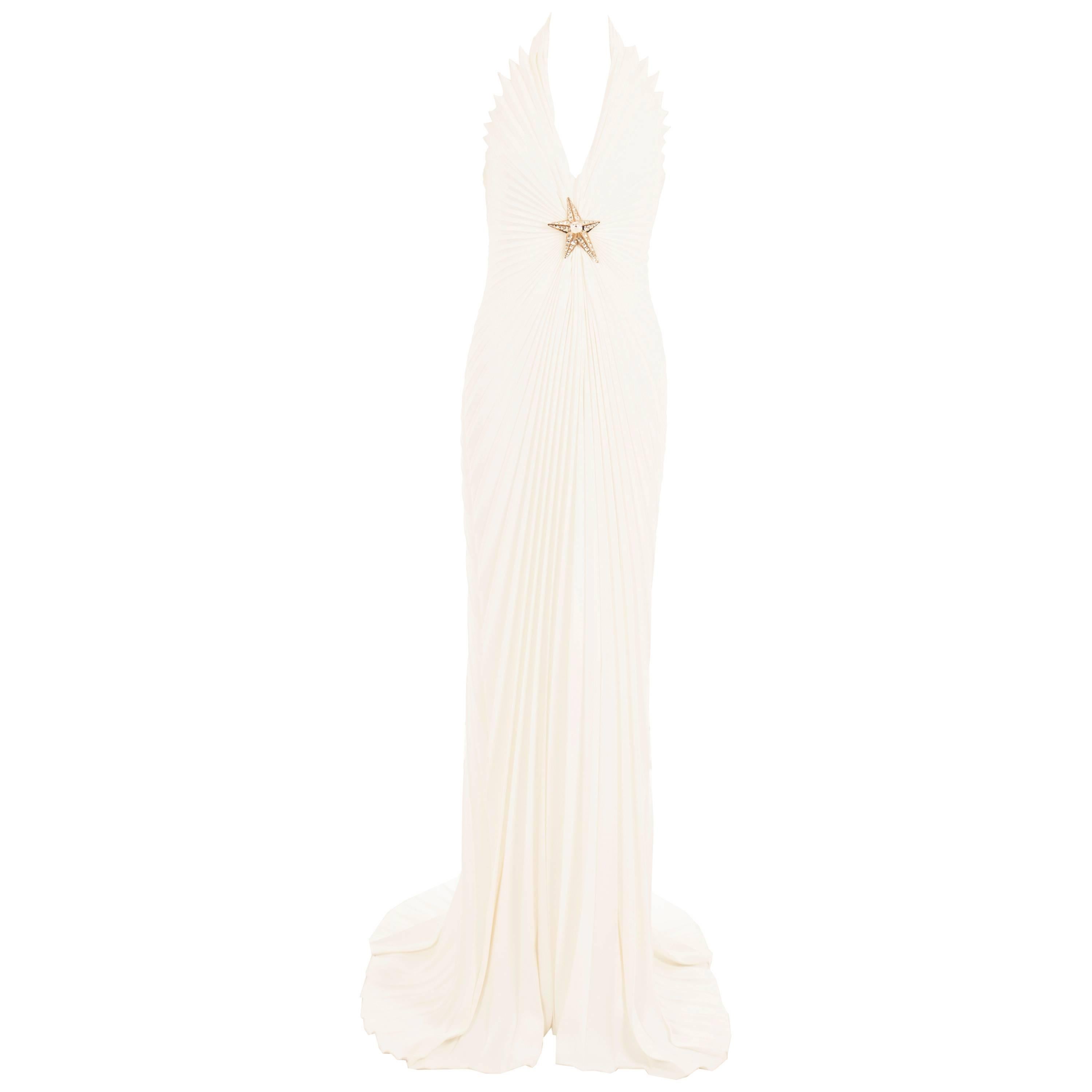 Conjuring images of Marilyn Monroe in her iconic white dress from ‘The Seven Year Itch’, this incredible Thierry Mugler halter neck gown screams red carpet glamour. The snow white polyester is pressed into accordion pleats and draped over the body