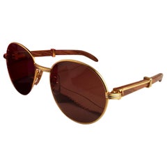 Cartier, nouvelle lunette Bagatelle ronde en bois dorée et palissandre précieux 55 mm marron, neuve