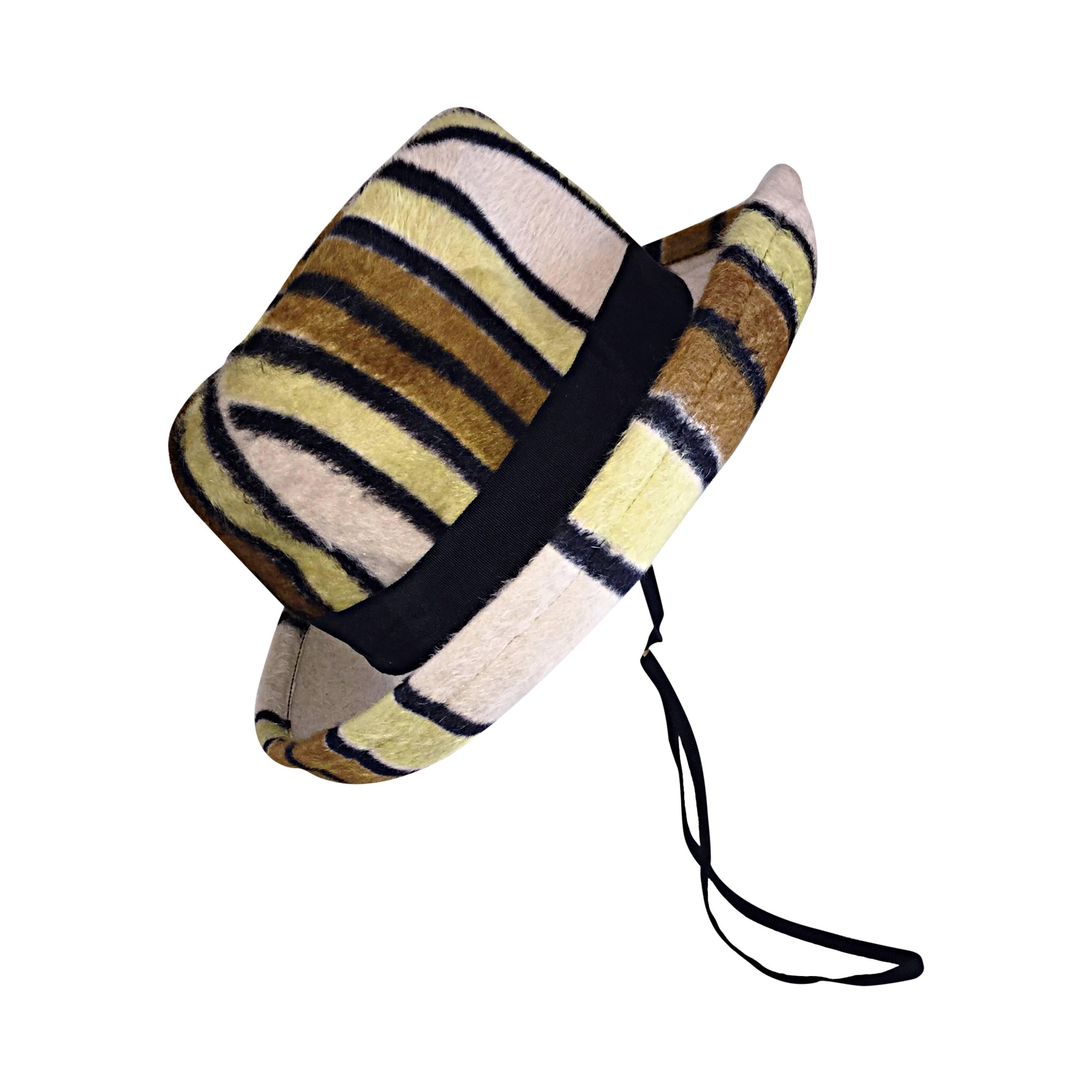 Rare vintage Yves Saint Laurent hat! Features stripes of brown, yellow, black and ivory throughout. Has an adjustable chin strap. Looks great on, and can be worn a variety of ways. In great condition. Would fit anywhere from Small-Large, given the