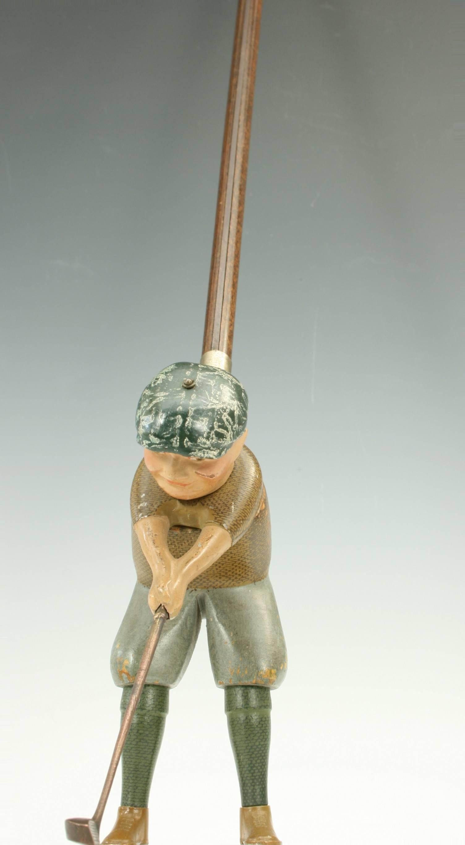 Schoenhut indoor male golf toy.
This indoor golfer is called Tommy Green. He is a wooden golfing figure attached to a wooden shaft, whose golf club will swing using a trigger mechanism. The figure stands 6 ½" tall and is attached to a 30