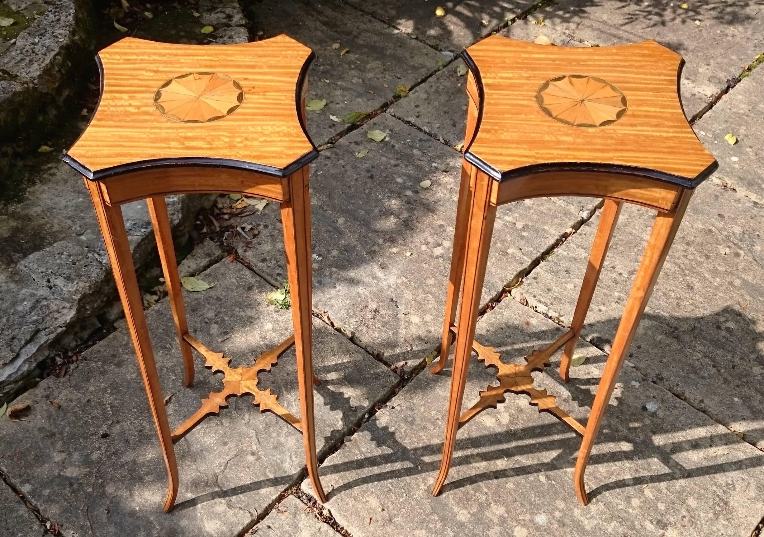 Fine pair of Georgian revival wine tables. This pair of tables are made of a particularly interesting cut of satin wood with Harewood / sycamore inlay and ebonized detail. The splay legs make them more stabile than their elegant design would