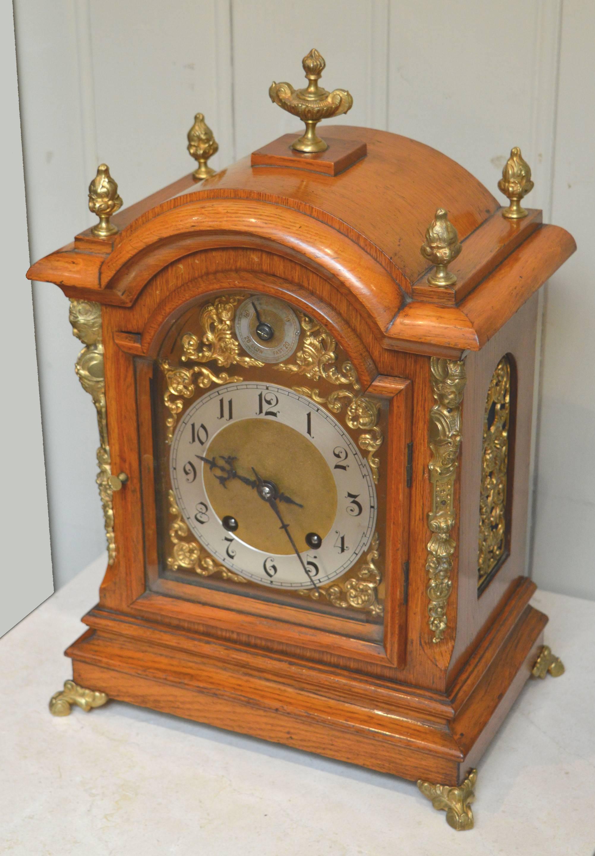 A good quality, solid light oak case bracket clock. It has a break arch top, with brass finials,a very thick bevel edge glass, canted and mounted corners, brass side frets and bracket feet. The brass dial has corner spandrels and a silvered chapter