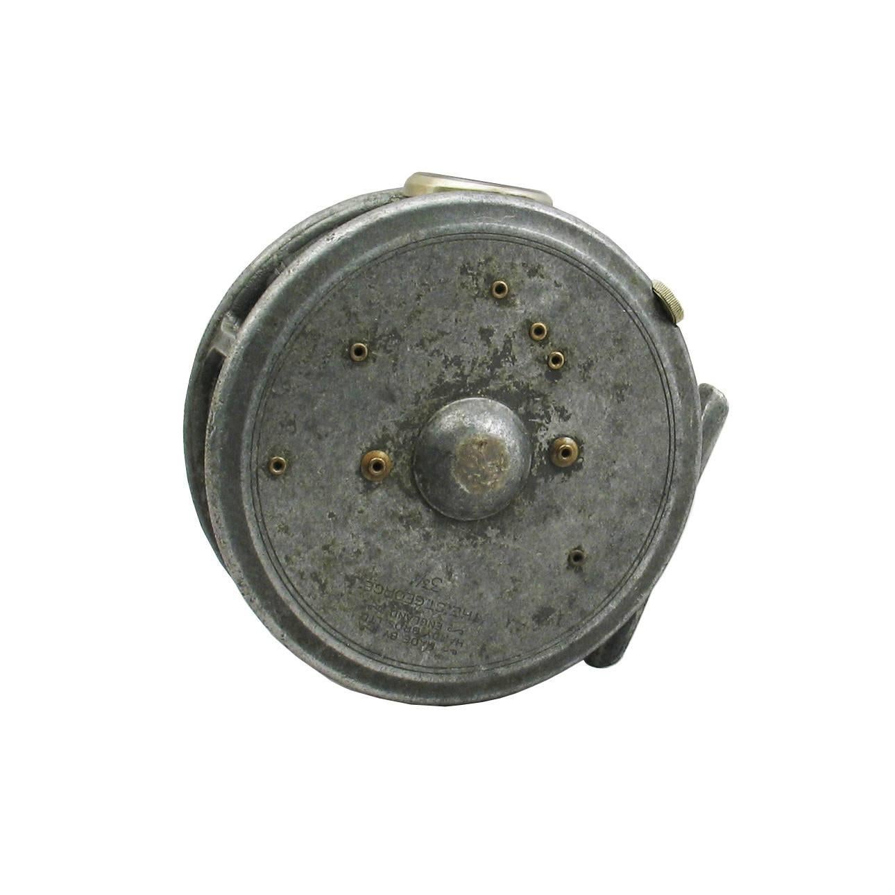 Pryce-Tannatt's personal fishing reel. This is a Hardy St. George alloy trout fly reel, it has a smooth agate line guide, rim tension regulator, brass foot modified two screw drum latch, smooth check, black handle and retains some original grey