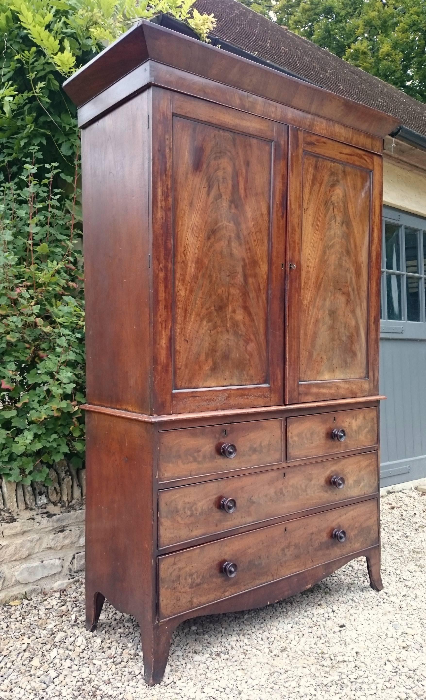 Antique linen press made of really fine flame mahogany with turned handles and splay bracket feet. 

English circa 1820 

52