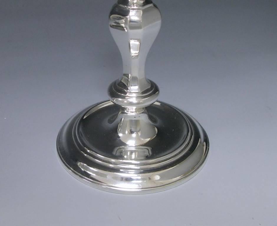 A very fine pair of late Queen Anne Style silver cast candlesticks. The candlesticks have a knapped stems and stand on circular bases which each have a sunken well and thread border. These beautiful candlesticks would grace any home.