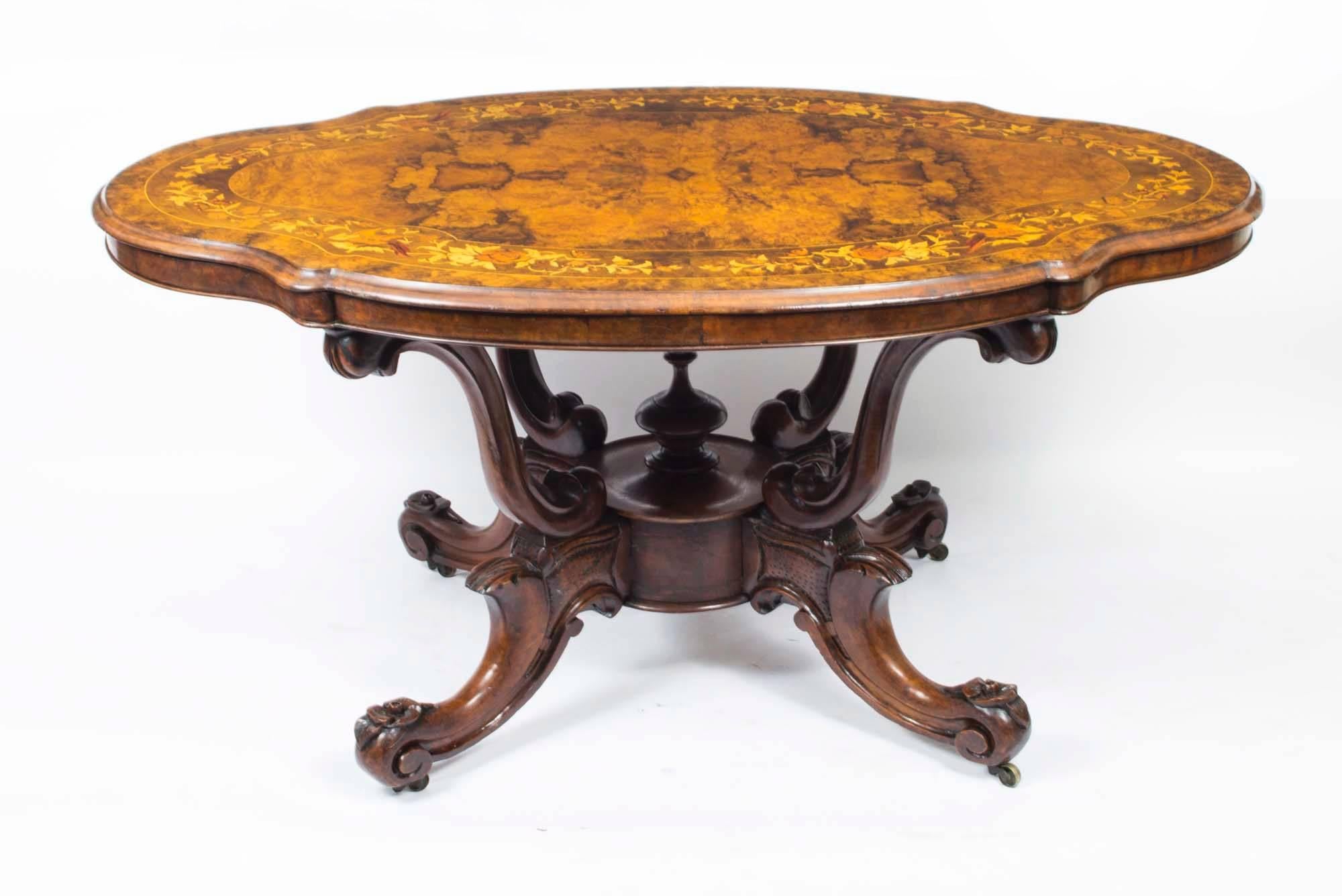 This is a superb Victorian burr walnut and floral marquetry centre table, with basket base, circa 1870 in date. 

The table top is a serepentine oval shape and features wonderful burr walnut with superb floral marquetry inlaid decoration. The