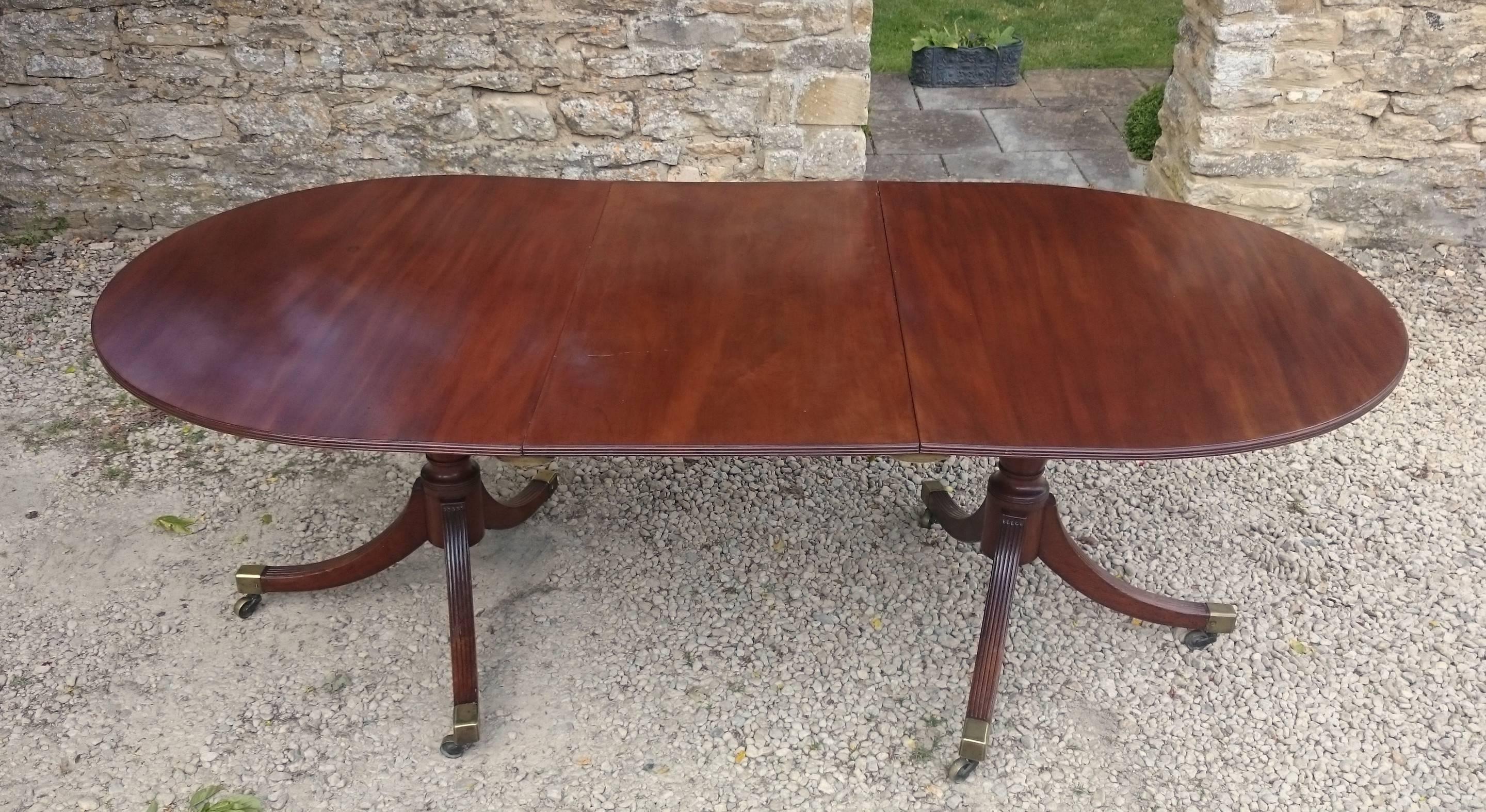 Antique George III revival twin pedestal dining table standing on outstretched three splay bases. This table has no frieze and so there is plenty of room for knees. Judging by the timber and the construction, the pedestals look as if they may be