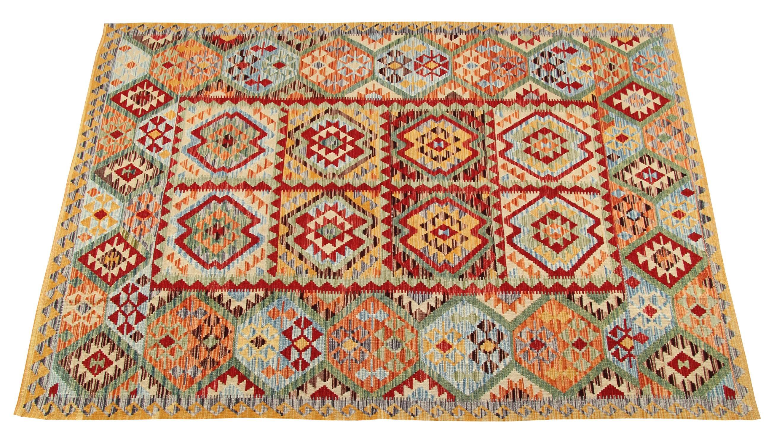 This Kilim rug has a varied use of colours; the aquamarine background is broken up by multi-colour designs and lines. The overall colours are soft and appealing: light blue, cream and light yellow, yet strong red accents interrupt the serene