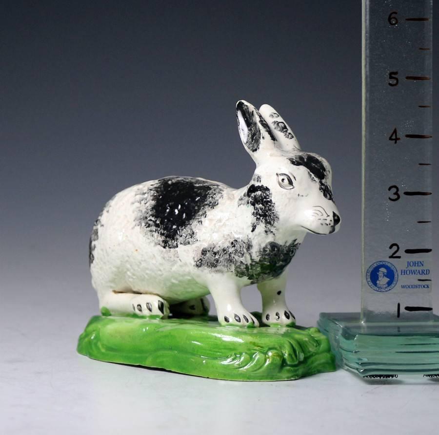 A very rare unrecorded figure of a pottery rabbit sponge decorated with black markings standing in crouched position on a green base. The figure is a good size and distinctive. 