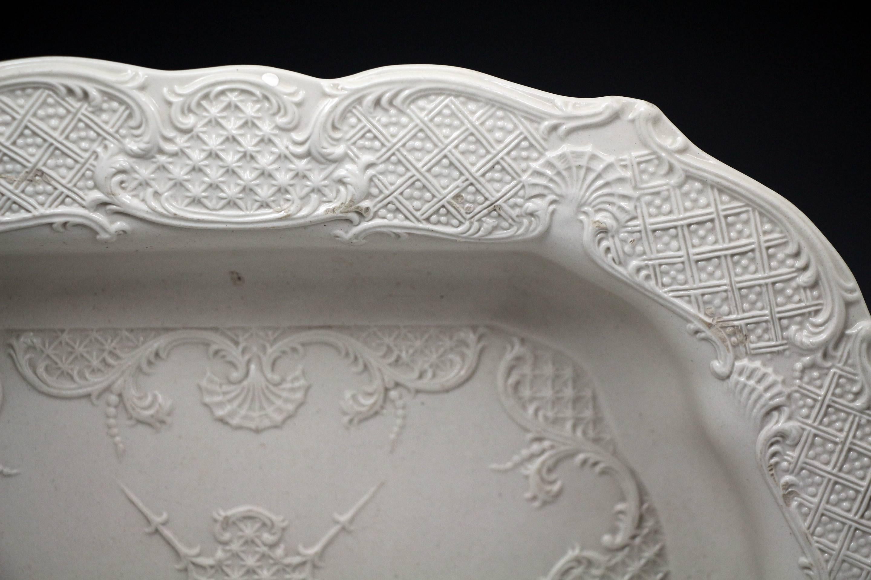 Salt glaze pottery stoneware dish decorated with elaborate rococo inspired relief molding patterns. 
The deep dish is in very clean crisp condition. 
A fine piece with texture and elegance, Staffordshire circa 1765 