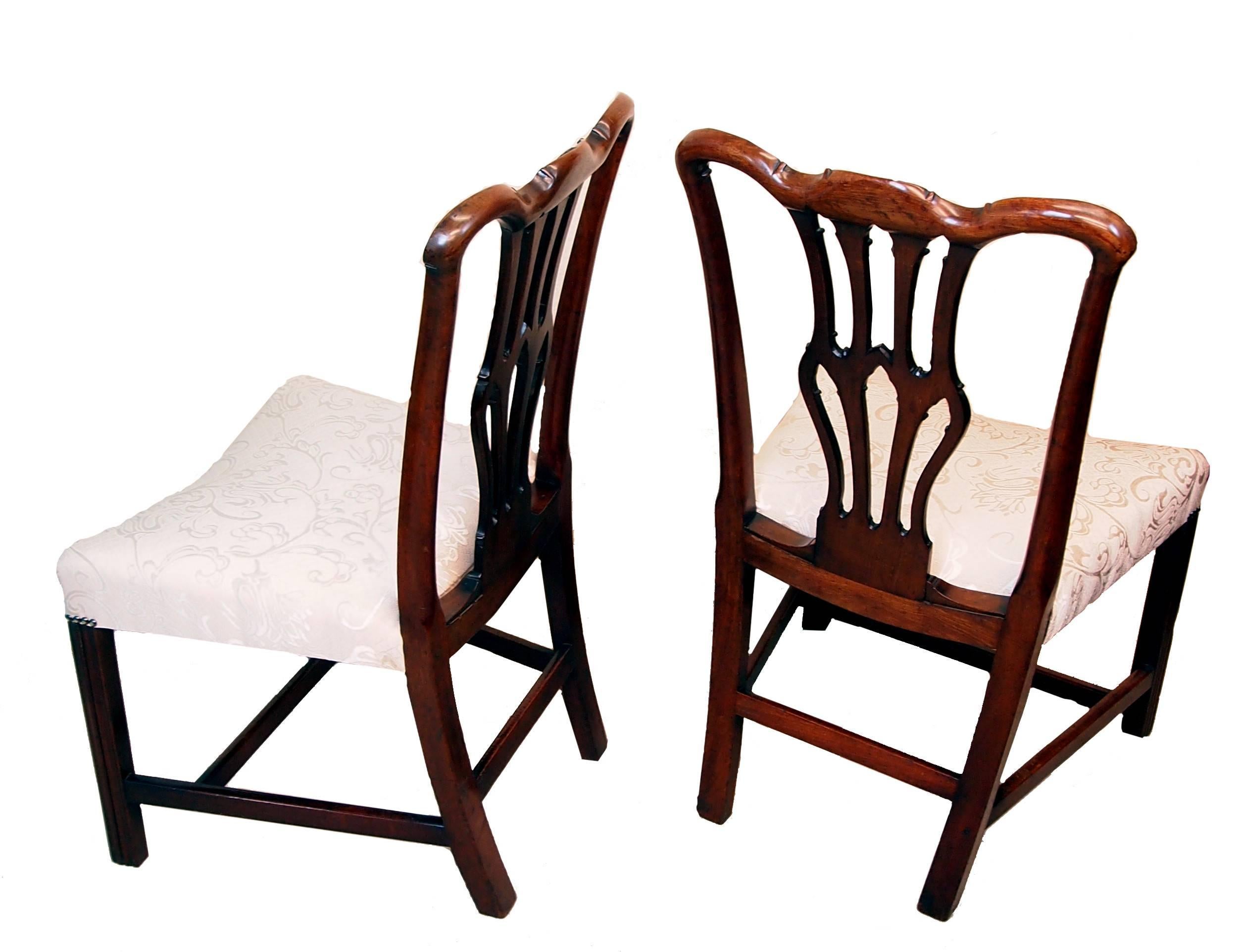 Une belle paire de chaises latérales en acajou de la période Chippendale ayant 
décor sculpté attrayant sur des dos d'éclisses percés et bien figure 
au-dessus d'inhabituels sièges arqués reposant sur des pieds carrés chanfreinés.