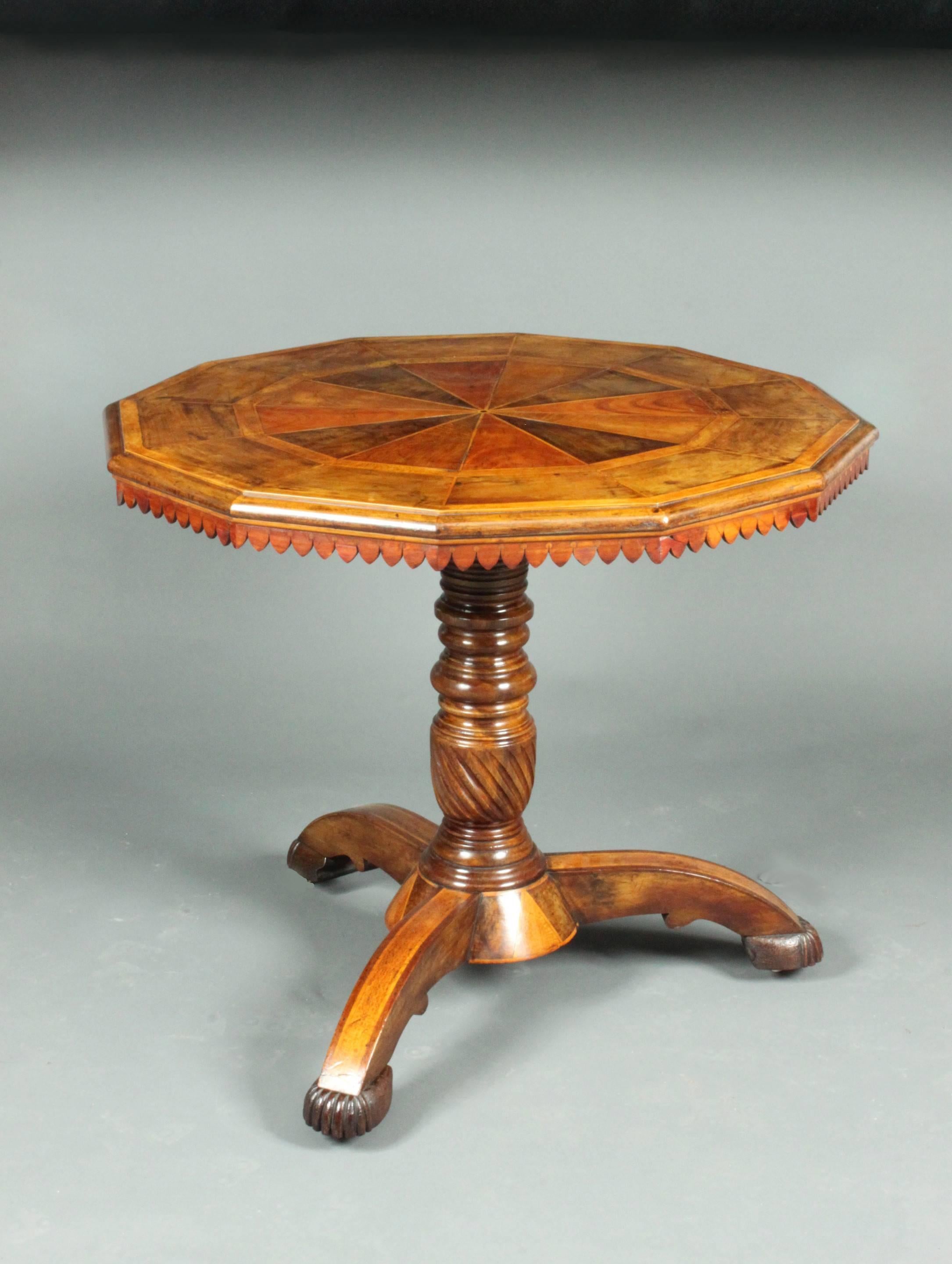 An amusing mid 19th Century 12-sided centre table with an inlaid segemnted top, a decorative frieze and an unusual inlaid base 