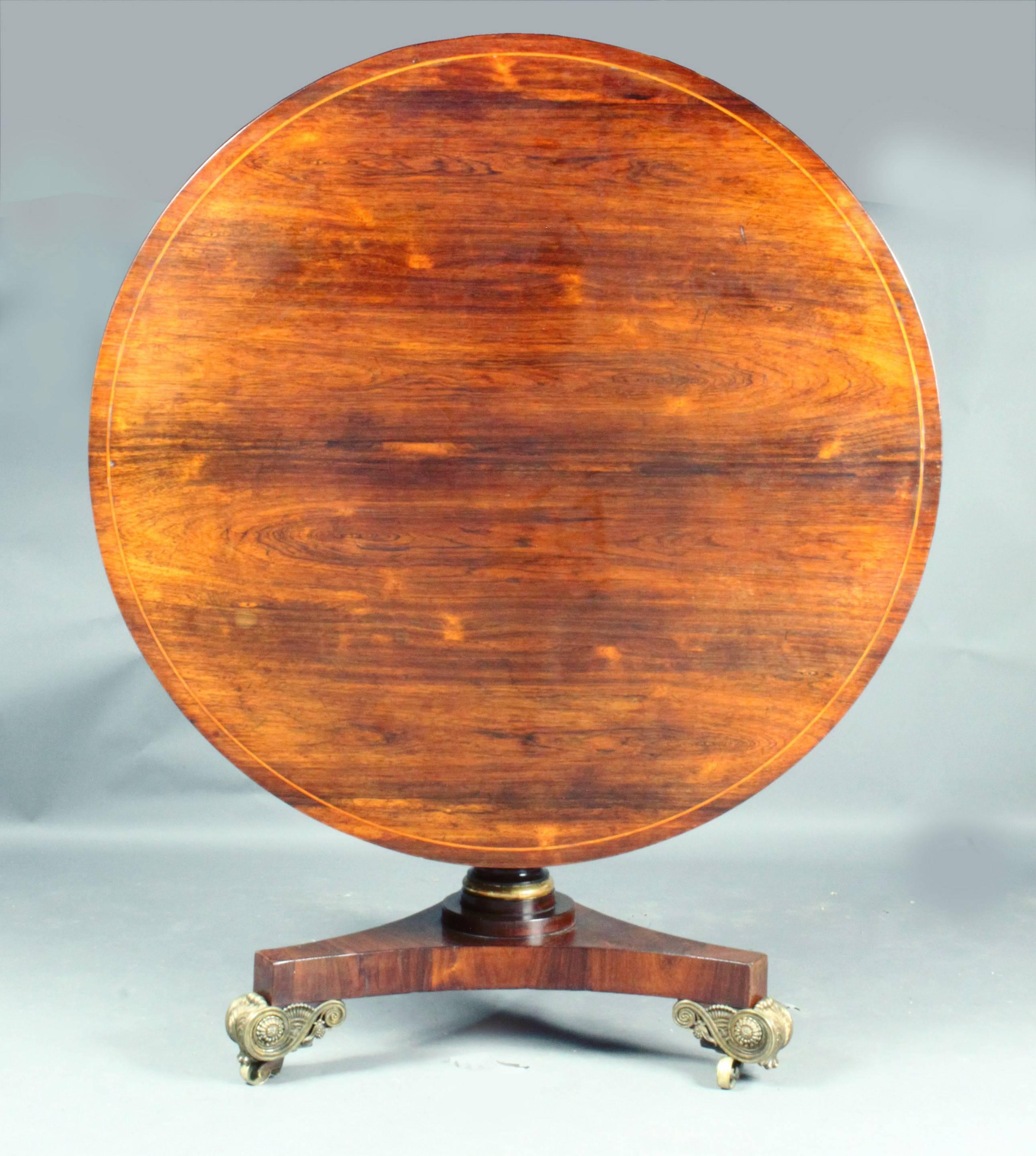 A fine Regency rosewood centre table of a rare small size; handsome stem in simulated rosewood with gilded collar; platform base with elegant scroll feet 