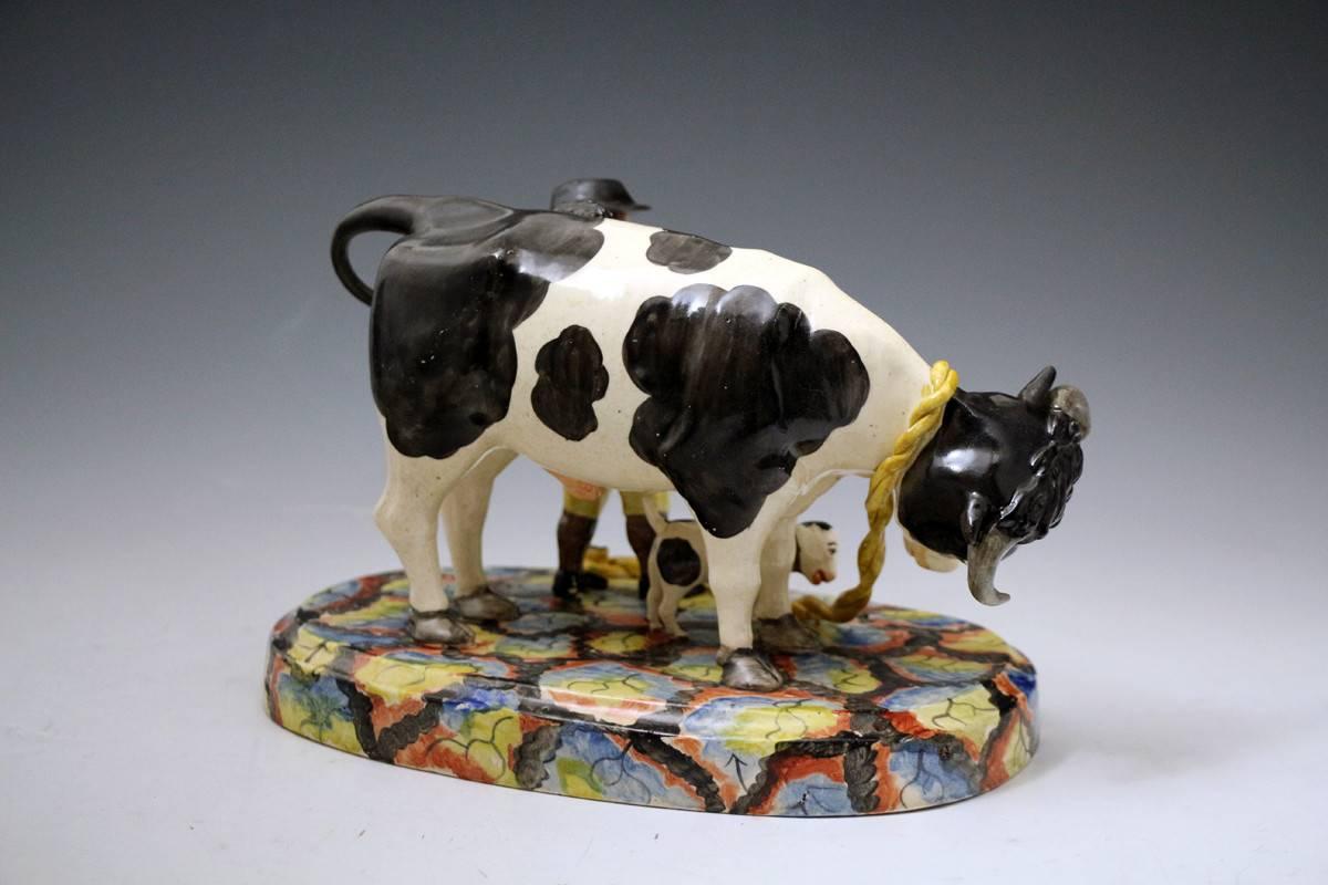 A very rare Staffordshire pearlware pottery bull baiting group. 
This piece is modelled with the most spectacular coloured base with well executed figures of a farmer the bull and a rather charming dog. 
The group is exceptionally well decorated