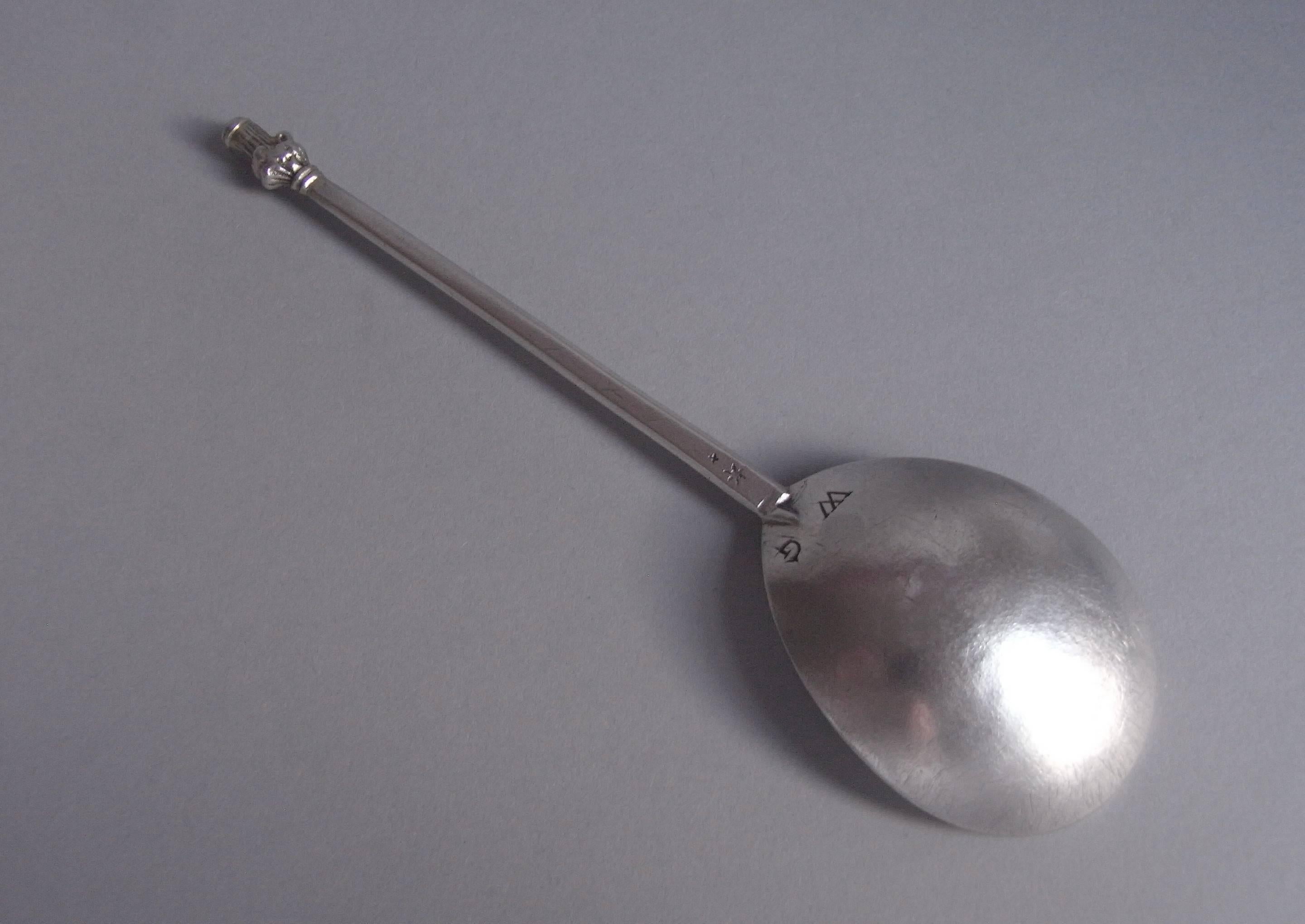 The Spoon has a fig shaped bowl and faceted octagonal stem. The top of the stem terminates in a finely detailed cast Maidenhead finial, which is palely gilded. The reverse of the bowl is scratch engraved with the contemporary initials WG. The Spoon