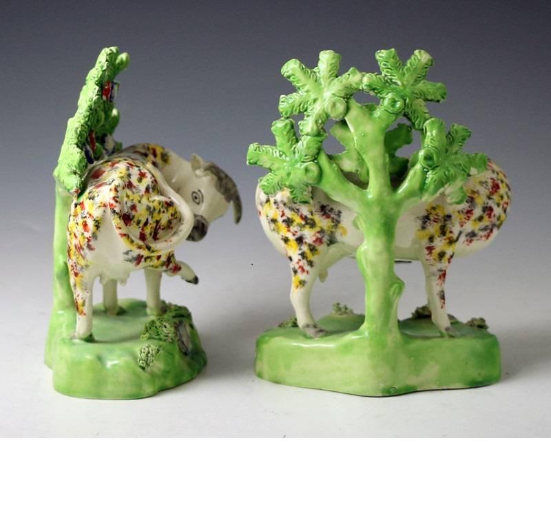 Pair of sponge decorated cows on bases with bocage, pearlware glaze from the 