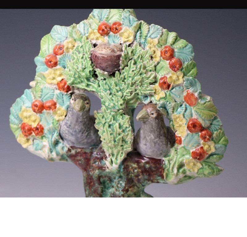 An amusing and highly appealing colorful Staffordshire pearlware pottery figure group with two birds perched in branches. The unique double leaved bocage is especially well modelled with exceptional detail to leaves and fruit. The base of the figure