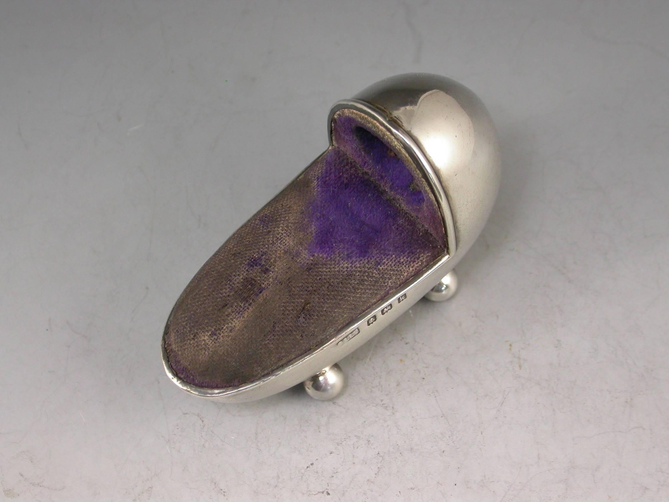 A good Edwardian novelty silver pin cushion made in the form of a crib standing on four ball feet, complete with original blue velvet cushion and integral thimble holder with gilt metal thimble. 

By Adie & Lovekin, Birmingham, 1909.