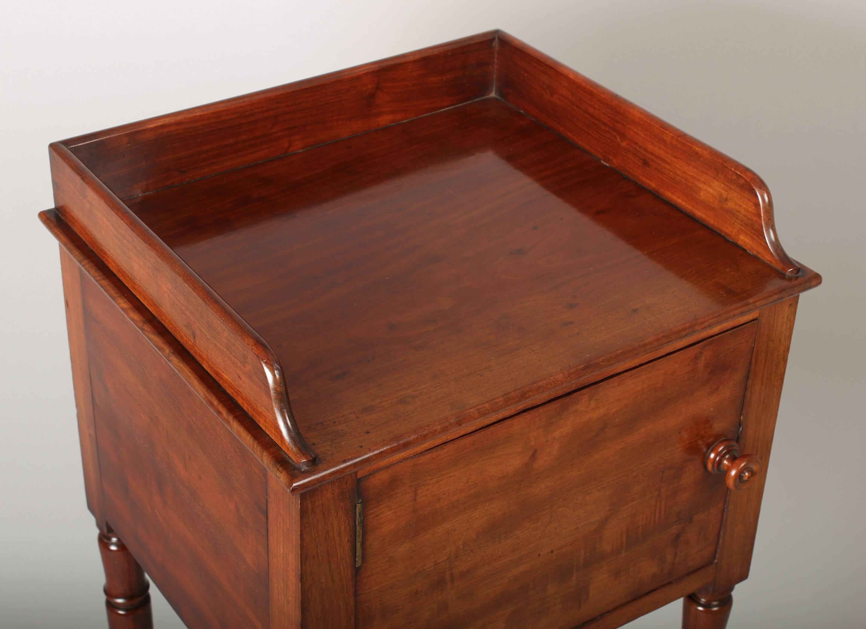 Early 19th century mahogany pot-cupboard with a galleried top and cupboard with a single left-handed door, on turned legs.
 