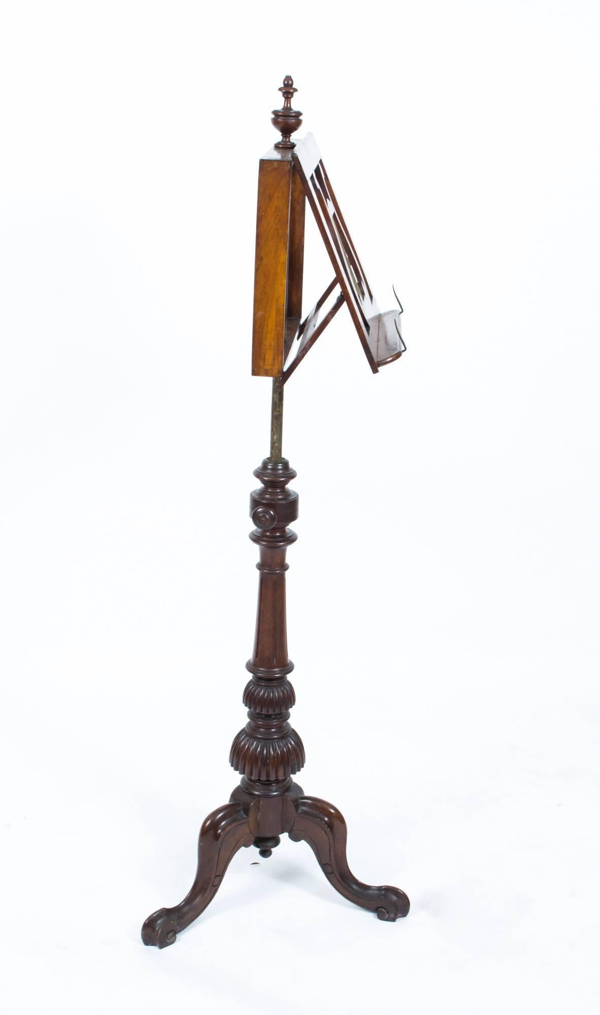 
Description: This handsome antique walnut and mahogany Victorian tripod music stand, is circa 1860 in date. 

It has been masterfully crafted with an adjustable book rest with a decorative lyre and a central turned finial, which can be raised or