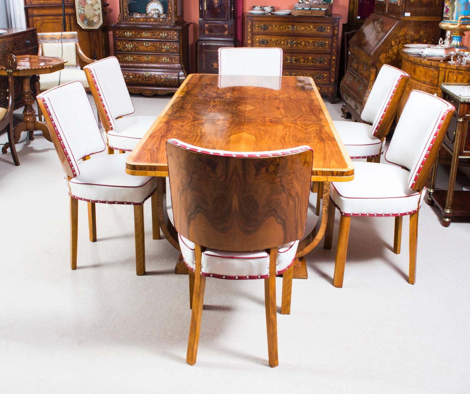 This is a beautiful antique Art Deco burr walnut dining set, comprising a burr walnut extending table and the matching set of six chairs, all circa 1930 in date. 

It features a rectangular top over U-shaped twin pedestal legs on splayed feet. It