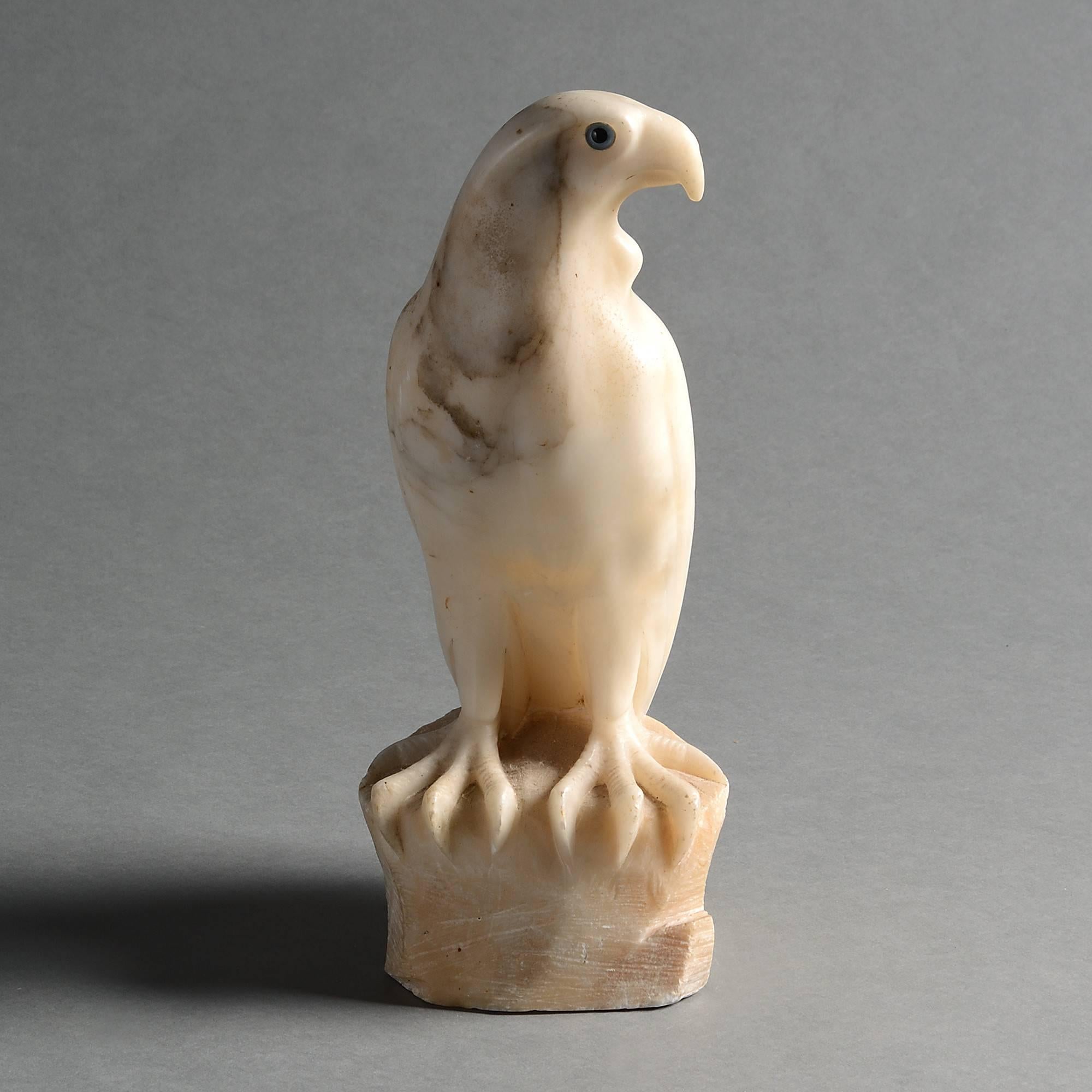 A late 19th century alabaster falcon, carved standing upon a rock and having blue glass eyes. 

In Chinese culture, the falcon represents keen vision, boldness and swiftness; Europeans believe that it symbolises liberty, victory and freedom - be