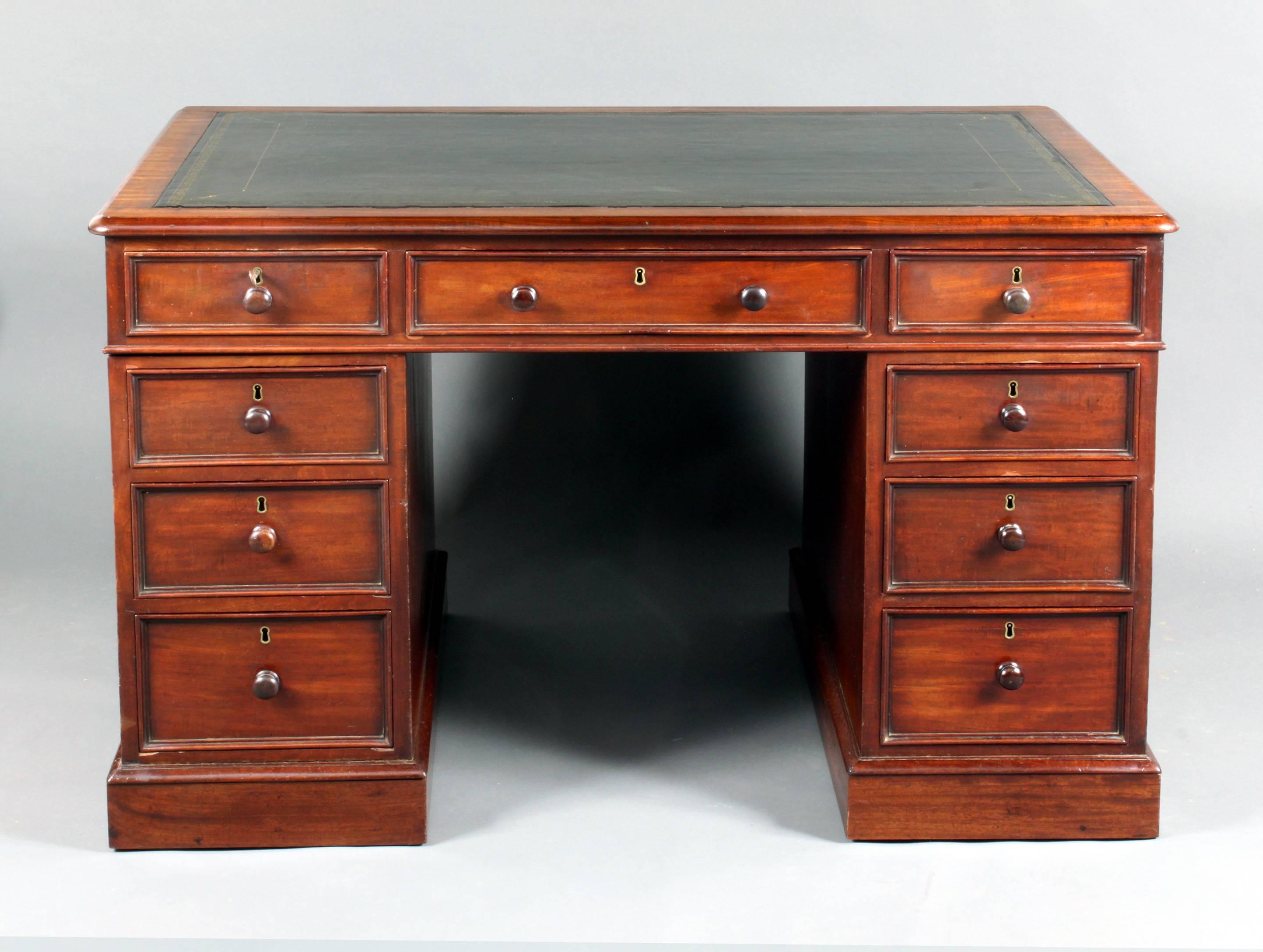 A fine quality figured mahogany pedestal desk: Good model with raised drawer mouldings, false drawers on the back, oak drawer linings and recently fitted dark green hide.