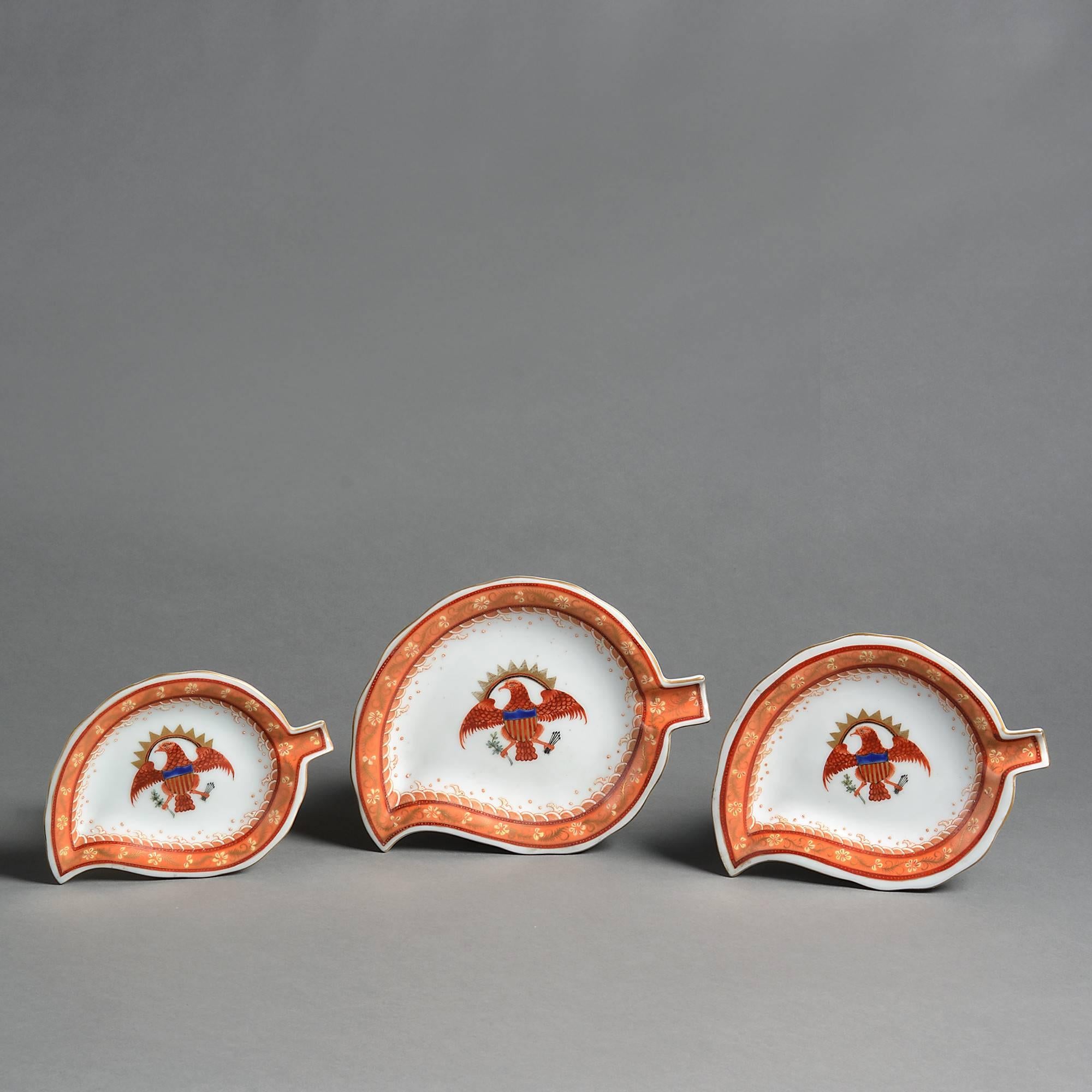A set of three Chinese Export style porcelain leaf dishes, decorated with red, blue, green and gold glazes upon a white ground, each depicting the Great Seal of the United States: A bald eagle proper displayed bearing in its dexter talon an olive