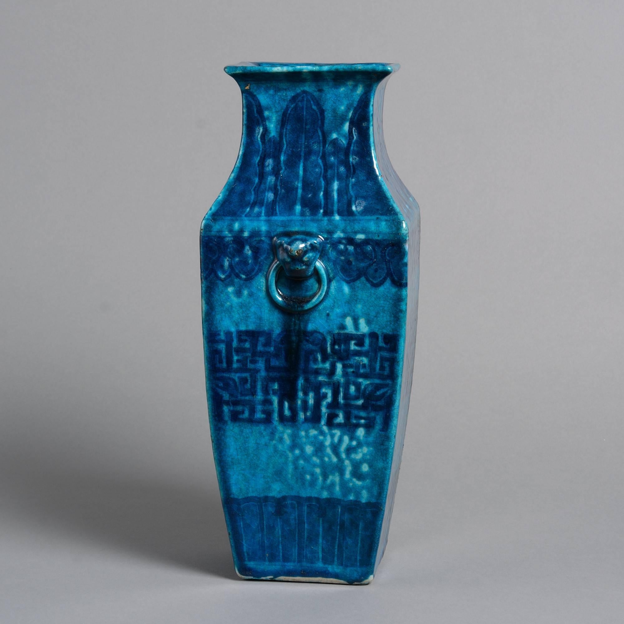 A mid-19th century vase of square tapering form with lotus leaf and geometric decoration on a turquoise ground.