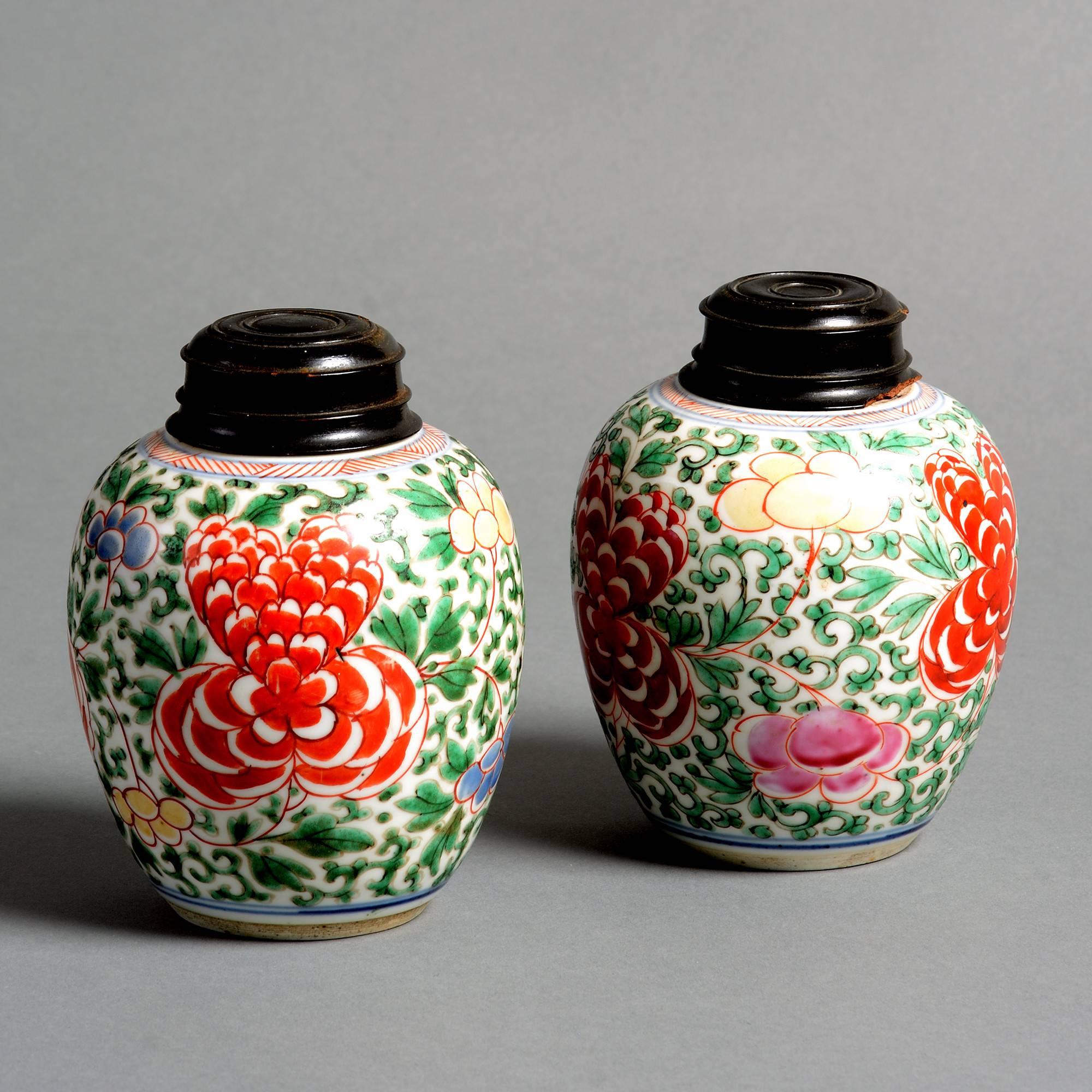 A pair of small-scale Kangxi period Wucai porcelain jars, decorated with floral and foliate motifs. 

Later wooden lids (one slightly damaged). 

P. 8.
