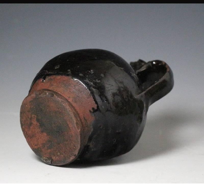 Blackware cistertian type bottle flask with handle. The thick deep black glaze is expertly applied on dark red clay.This type of ware was produced in Derbyshire,Yorkshire and the Midlands from the 15th to the early 18th century.