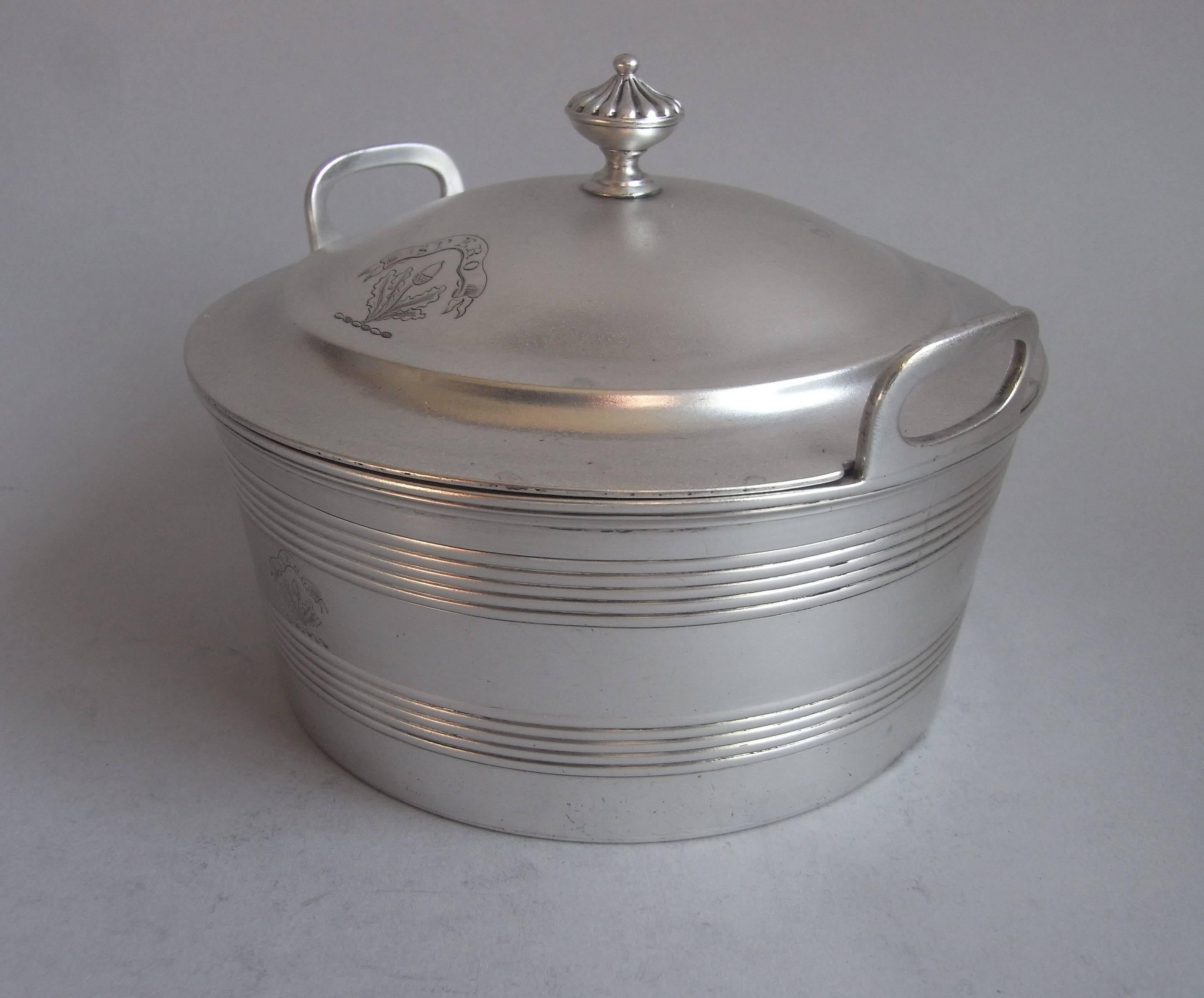 The Dish is realistically modelled as a butter churn with plain side handles and wide reeded bands, to simulate the metal bands on the churn. The stepped domed cover terminates in an urn finial decorated with lobing. Both the main body and cover are