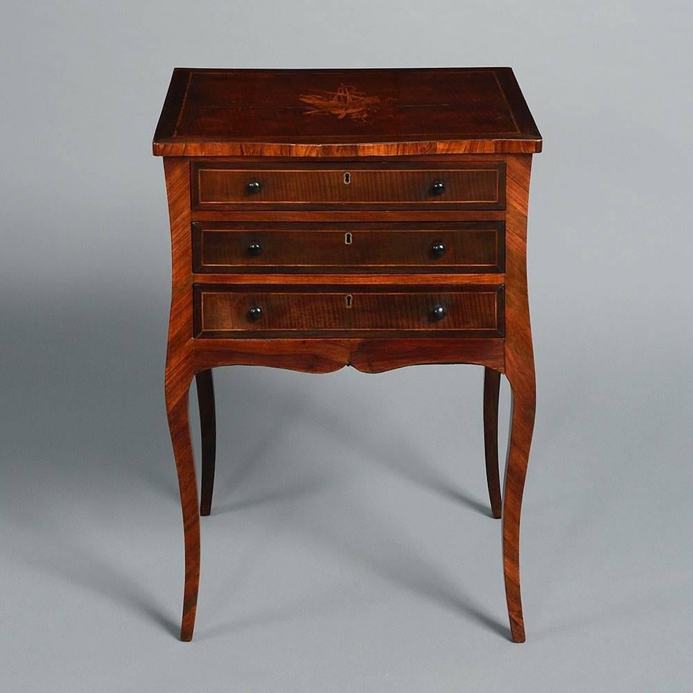 A fine 18th century George III Period kingwood bedside cabinet or nightstand, the shaped top with detailed marquetry of trophies above three drawers, all raised on lightly formed cabriole legs. 

This model relates to designs by Ince & Mayhew, a