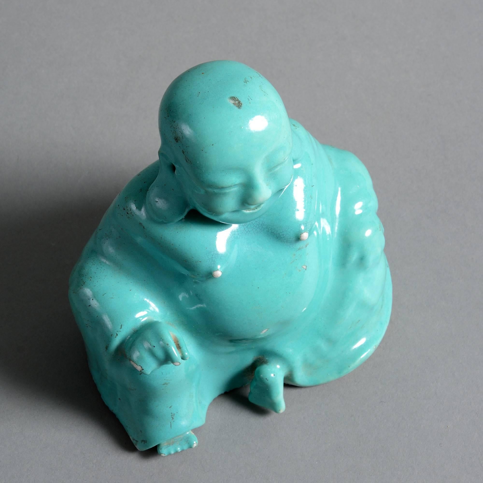 An early 19th century porcelain model of the seated Buddha decorated with a turquoise glaze. 

Qing Dynasty, Daoguang period. 

Condition: Good with occasional old glaze chips.