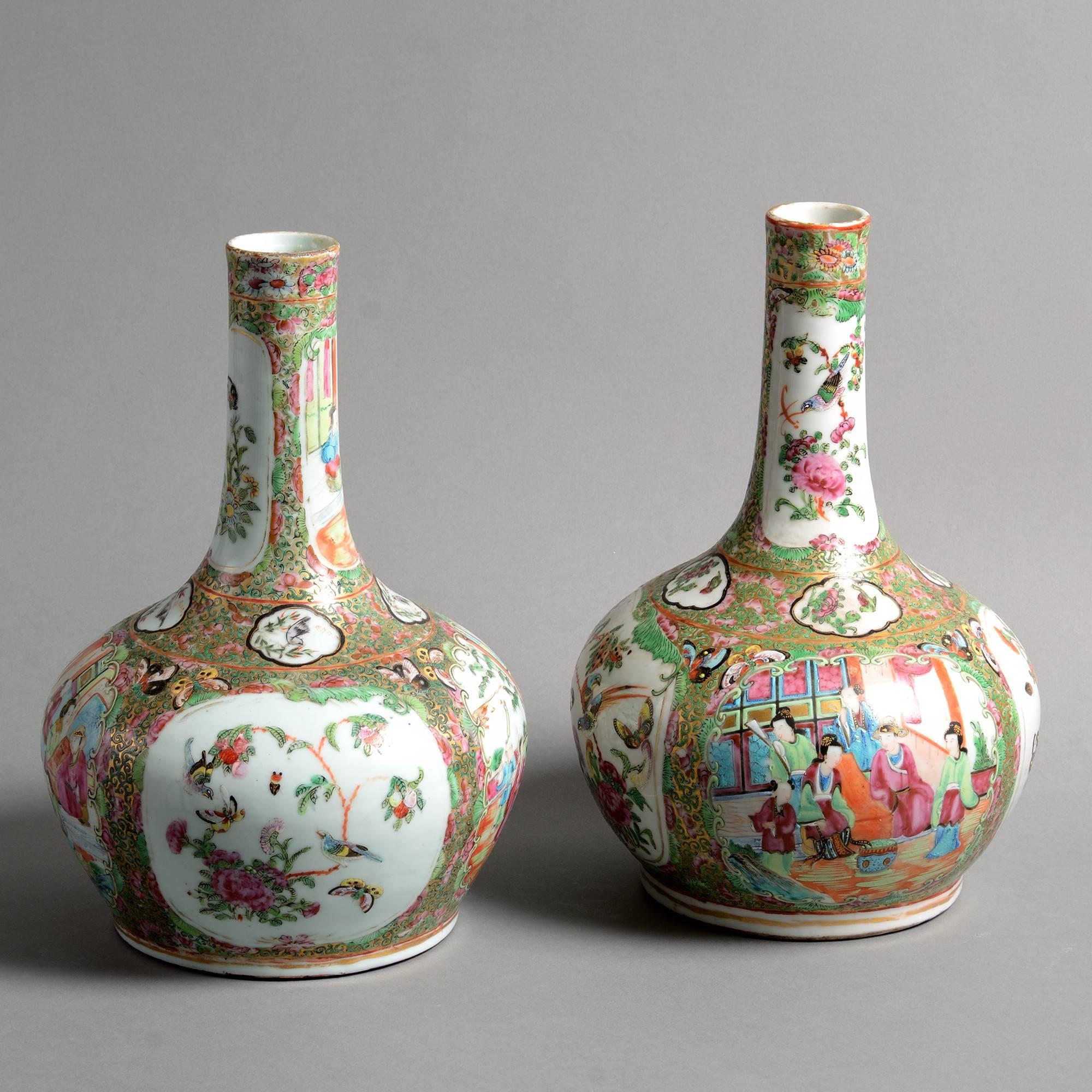 A pair of late 19th century famille rose Canton porcelain bottle vases, decorated with cartouches of court scenes, birds and butterflies. 

Made for the Export Market.

Qing dynasty, Guangxu period. 

Condition good; bases drilled.