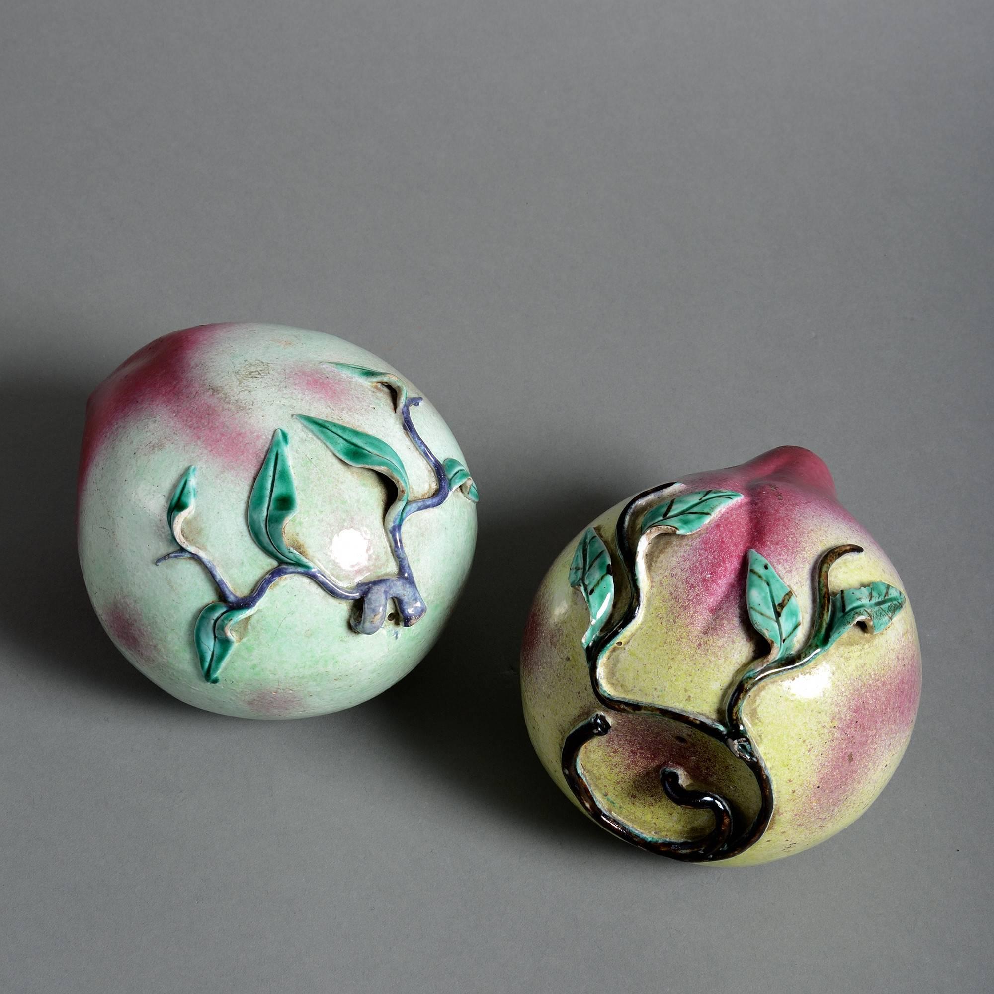 Two late 19th century porcelain peaches, with brilliant pink and green glazes and naturally modelled leaves. 

Qing dynasty, Guangxu period.

Condition: Some old chips to leaves.