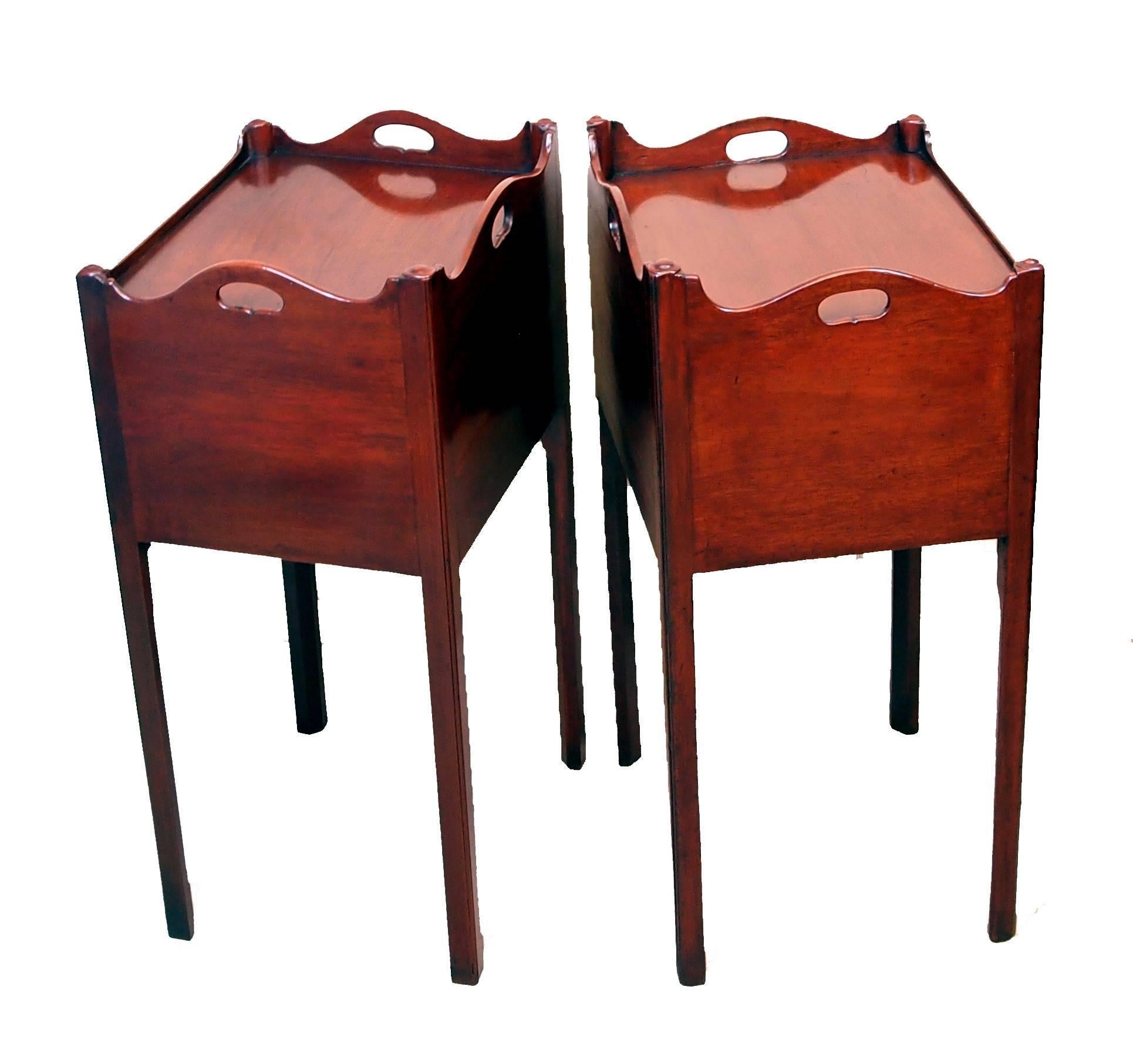 A delightful matched pair of George III period mahogany bedside
tables, or pot cupboards, having superbly figured shaped tray
tops above cavity raised on elegant square chamfered legs.