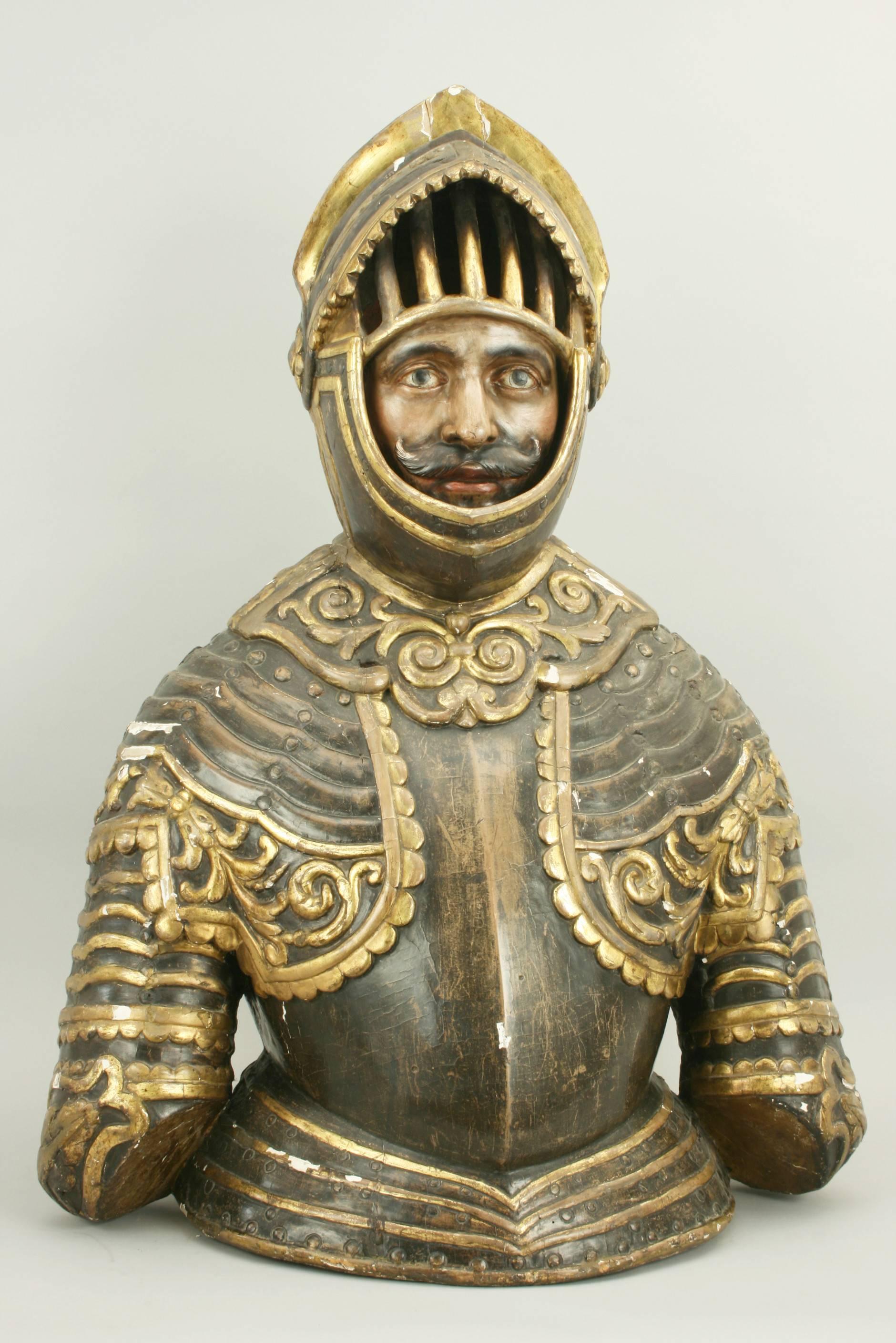 Wooden bust of a knight.
A wonderful armored knight carved from lime wood. The knight is well carved with the face (with moustache) looking out of the helmet with a raised visor. The black and gold Armour is well decorated; the helmet has a plume