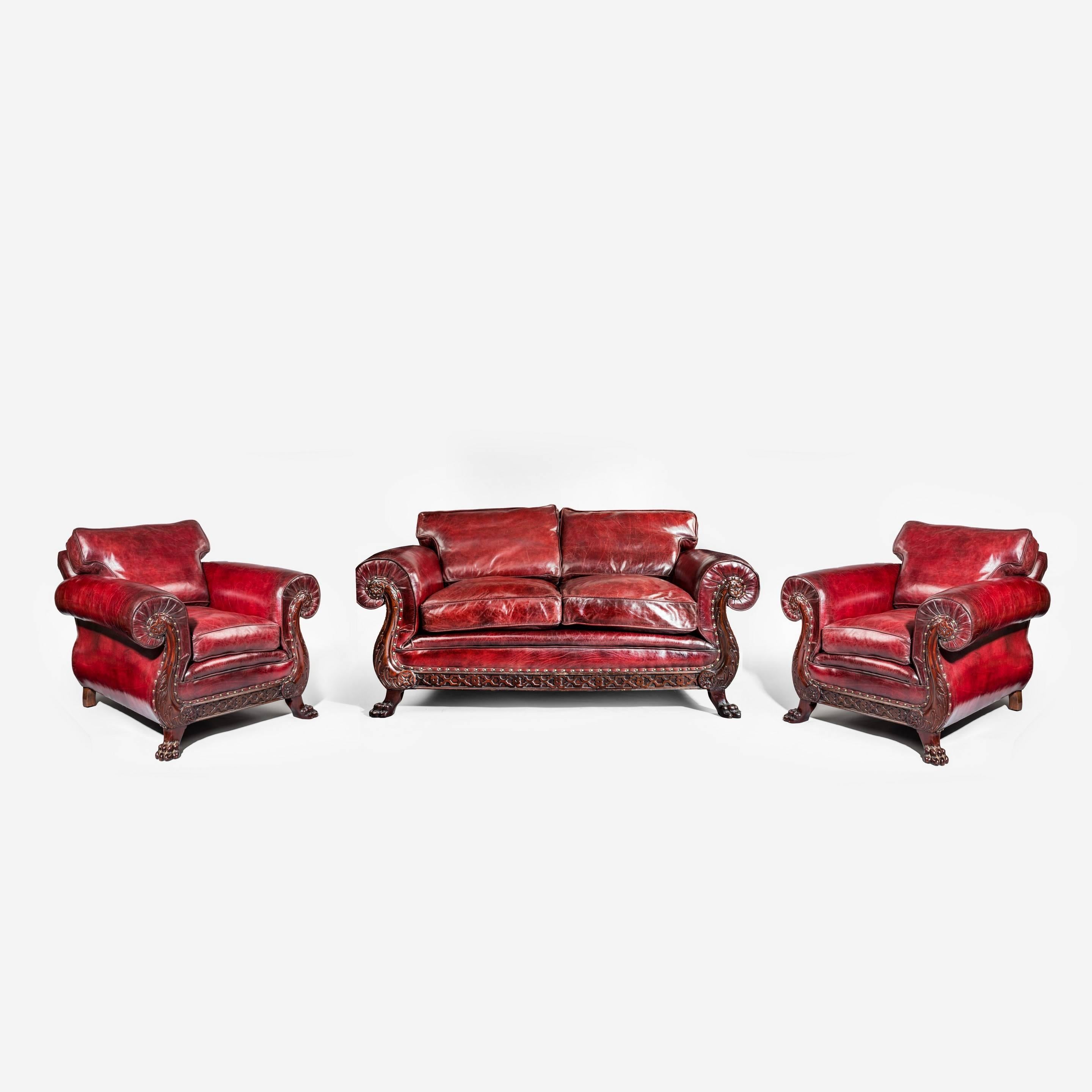A two-seat early 20th century mahogany oversized red leather sofa, with carved pawed feet, attributed to Maples. 

Matches beautifully the pair of armchairs we also have for sale.