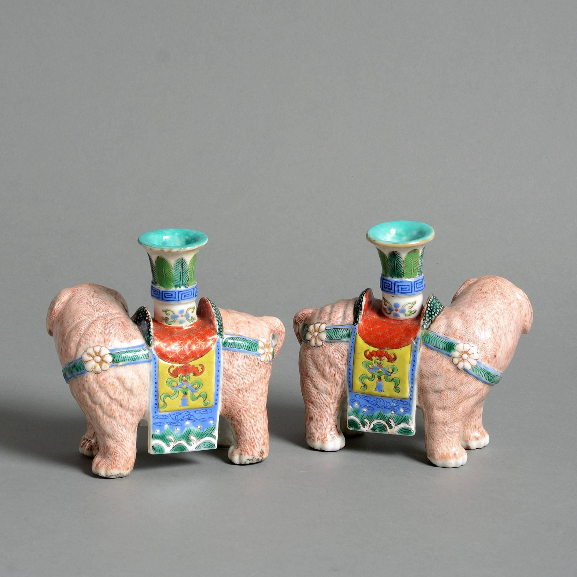 A pair of 19th century porcelain elephants, decorated in polychrome glazes with incense holders.