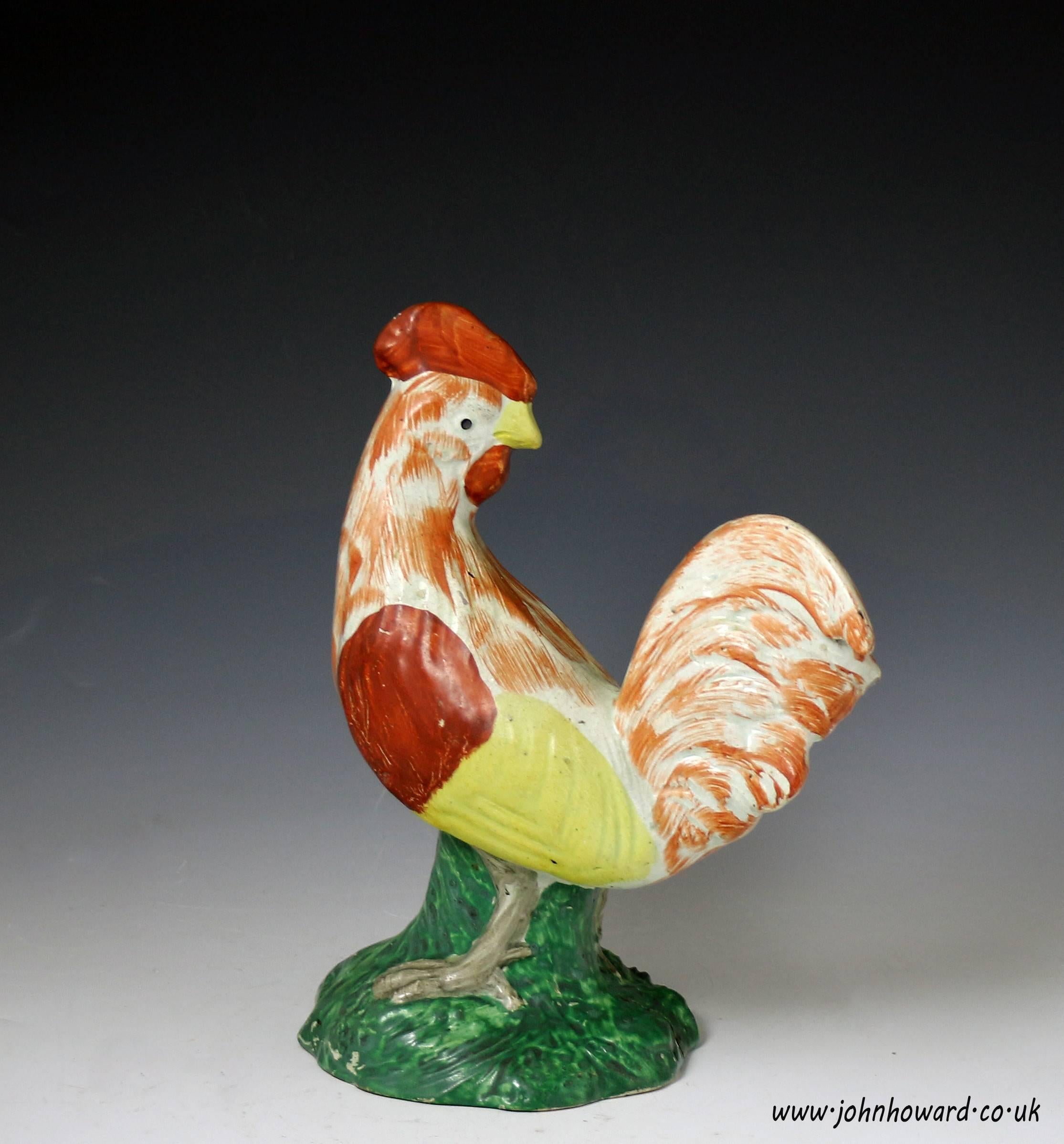 Antique early 19th century pearlware pottery figure of a standing rooster decorated in enamel colors. The naive modeling and color application enhances the boldness and character of the rooster.