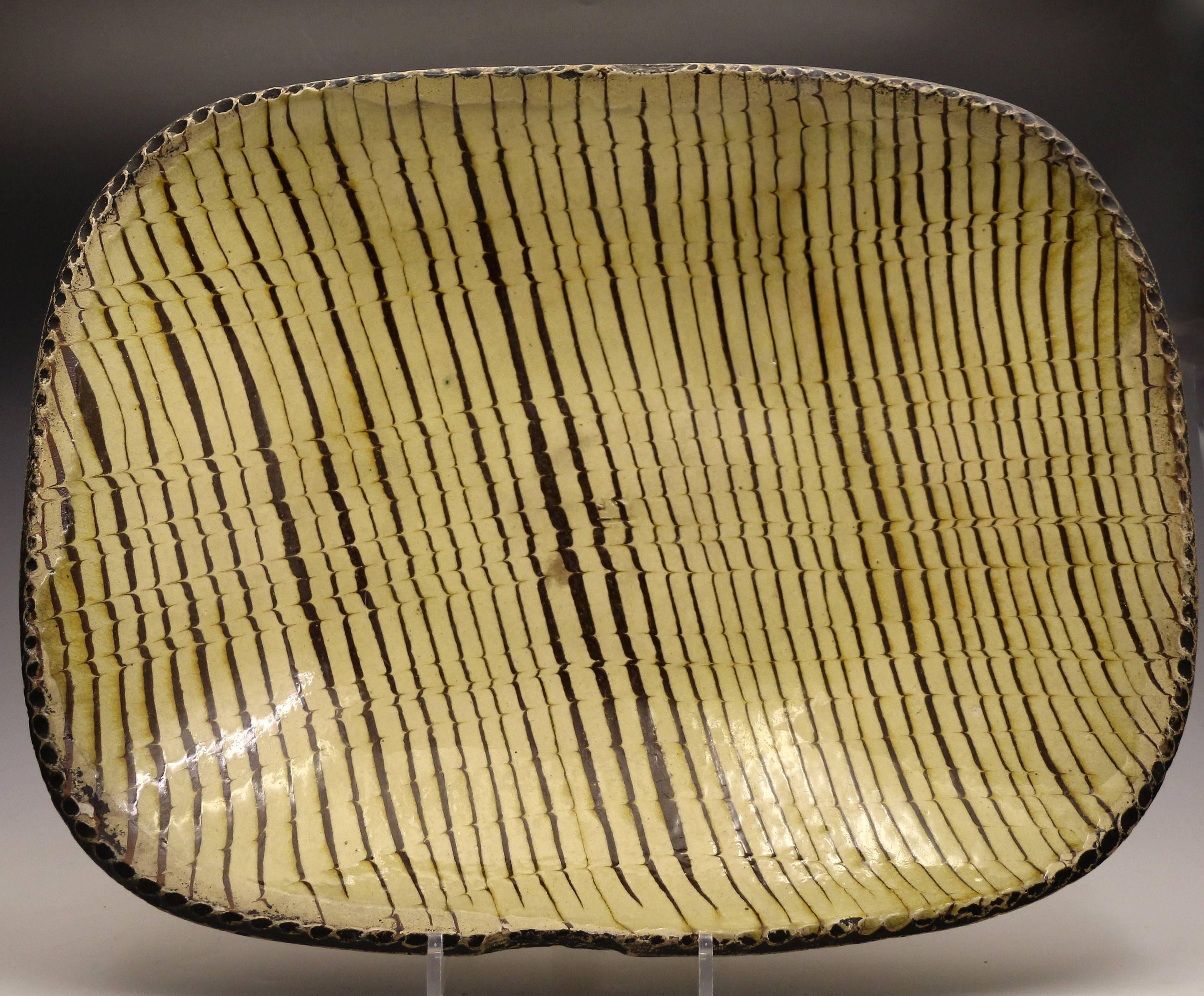 A fine and rare English earthenware comb decorated slipware baking/loaf dish.