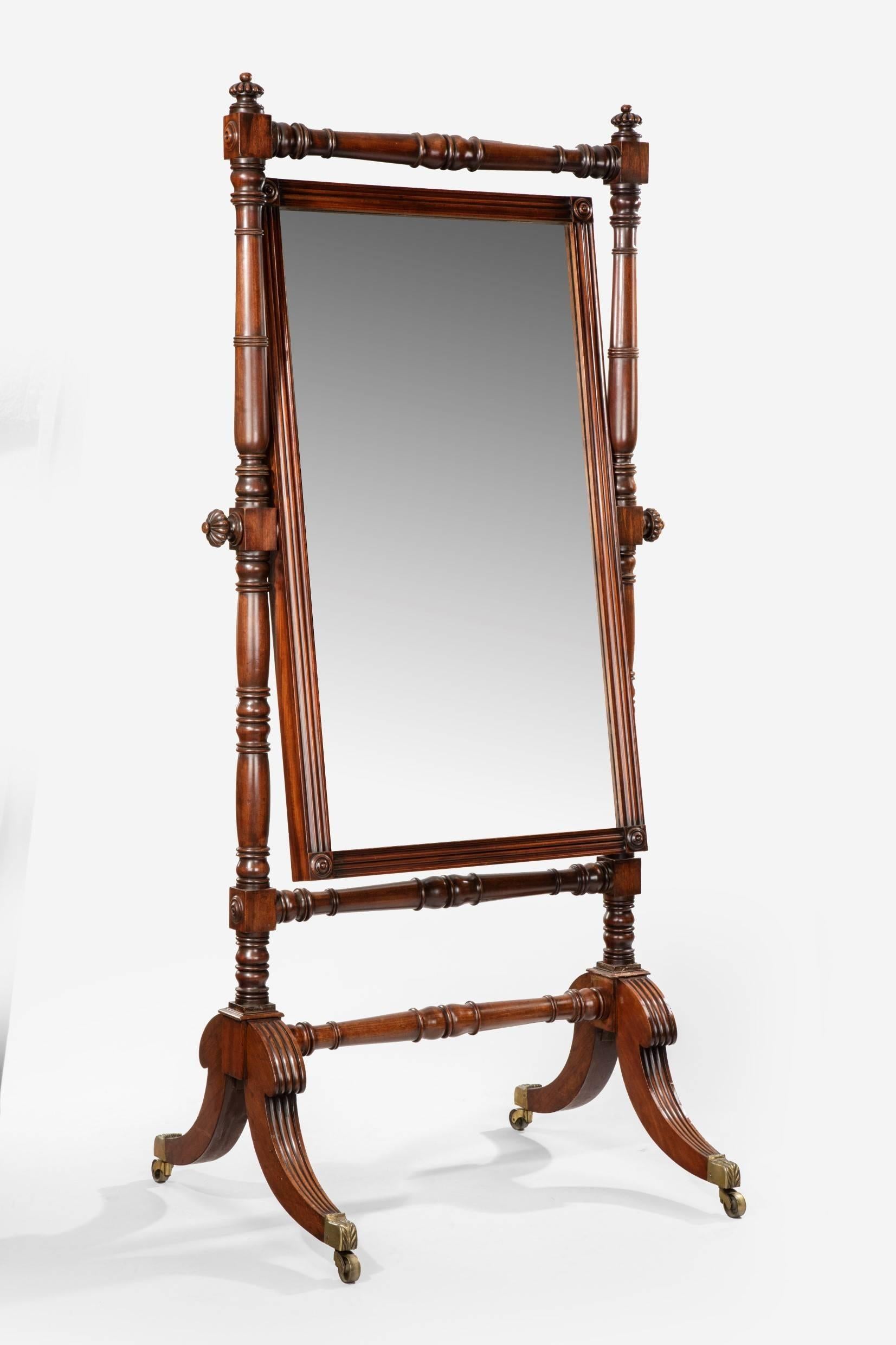 Regency cheval mirror, attributed to Gillows. Original rectangular mirror plate between turned column baluster supports joined by stretcher. On reeded cabriole legs with brass capped gilt-lacquer castors. Mahogany, circa 1815.