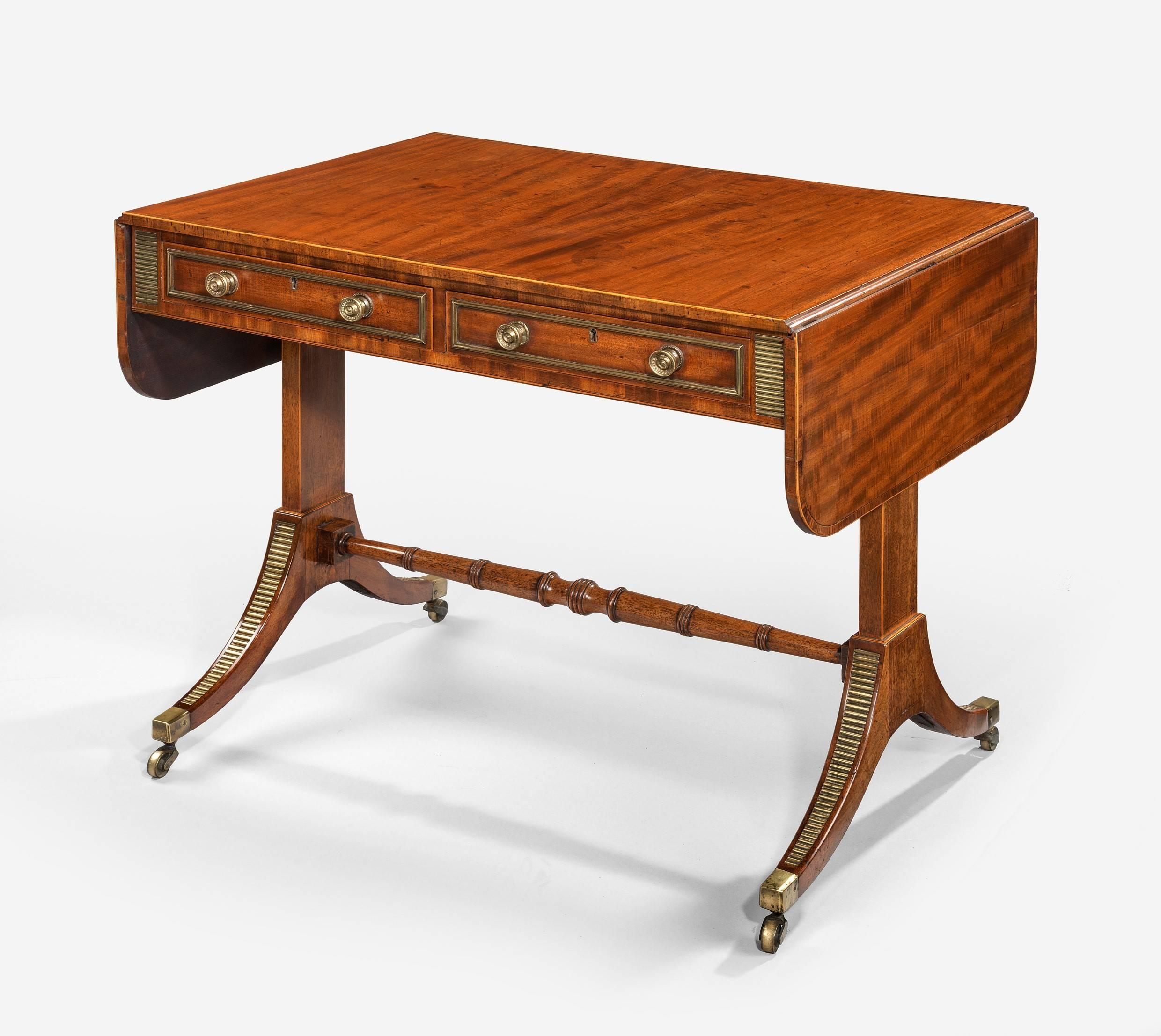 A fine quality brass-mounted end supported mahogany veneered sofa table from the workshop of John McLean & Son. This article has an original label inside the oak lined drawer and reads, manufactured & sold by John McLean and Son 58 Upper