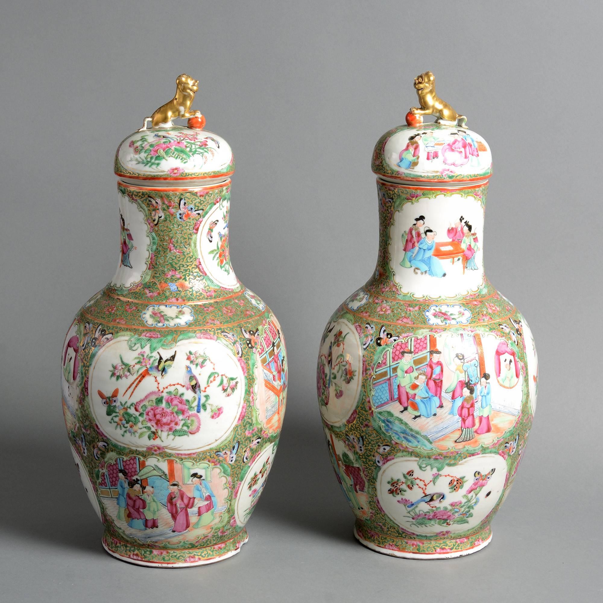 A fine pair of late 19th century famille verte porcelain vases, decorated throughout with figurative and ornithological scenes, the covers surmounted with seated gilded lions. 

Qing dynasty. 

Guangxu period (1875-1908).